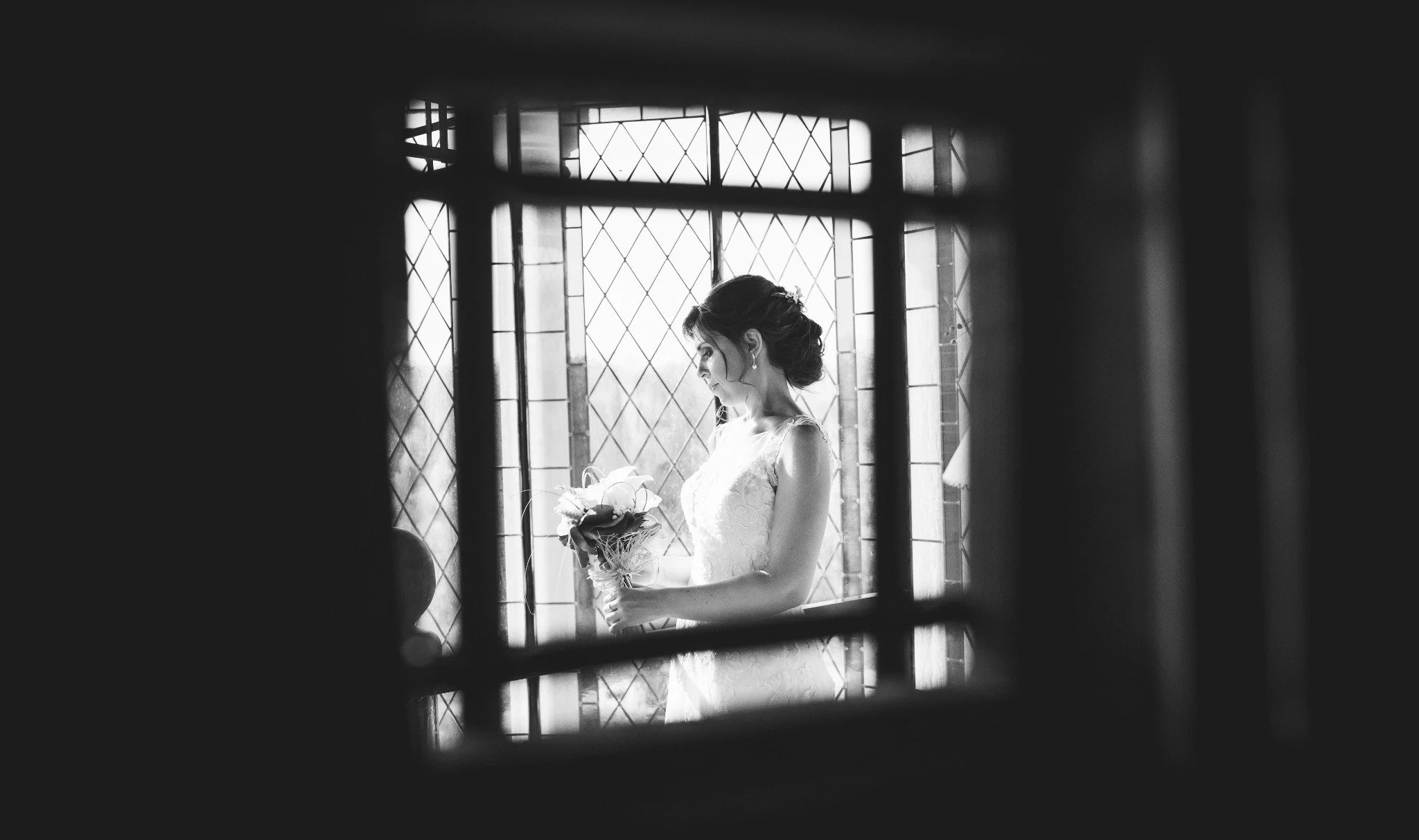 Retrato novia ventanal blanco negro en Aldea Santillana, Madrid.