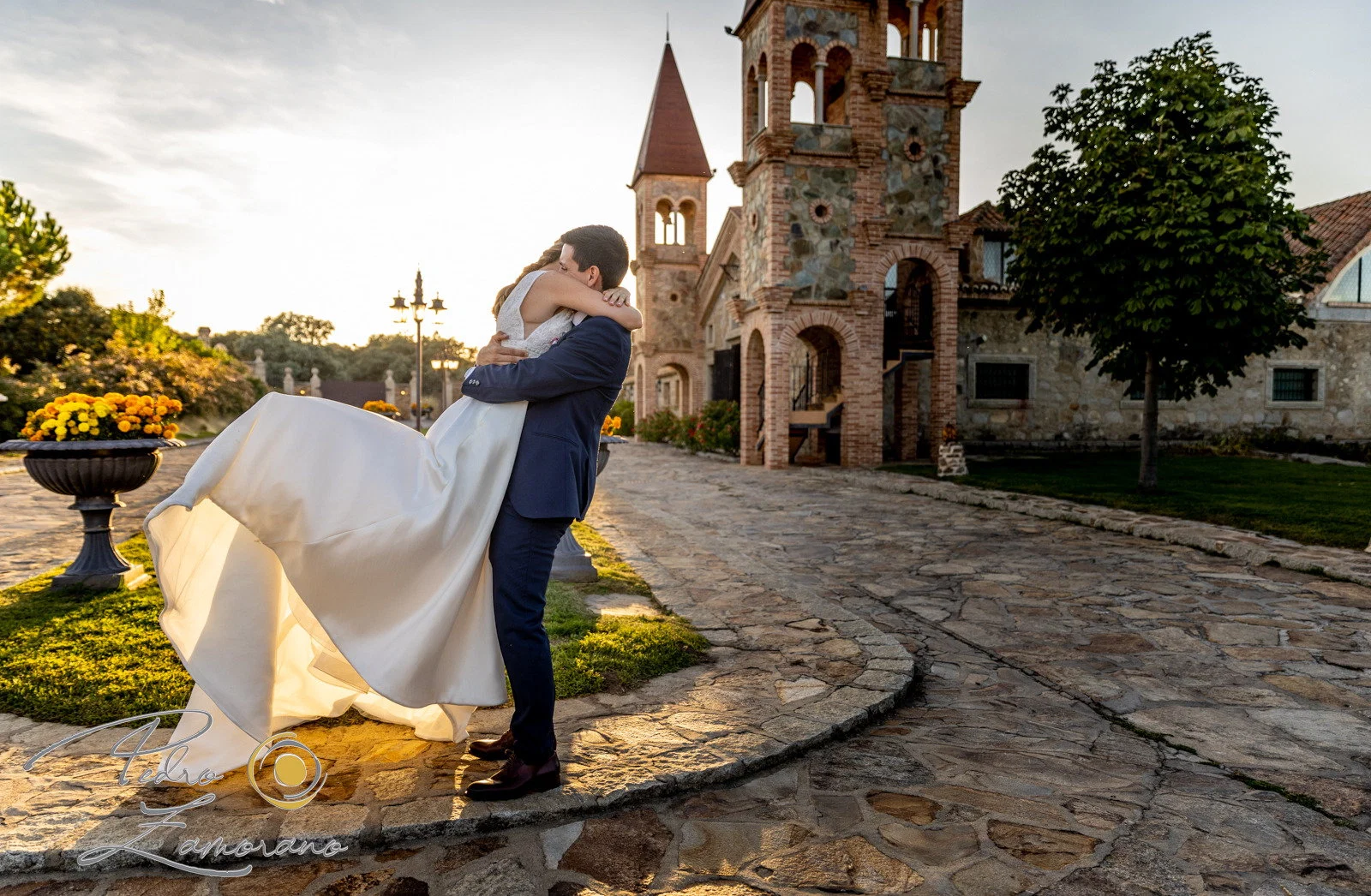 Novio levanta novia atardecer en Aldea Santillana, Madrid.