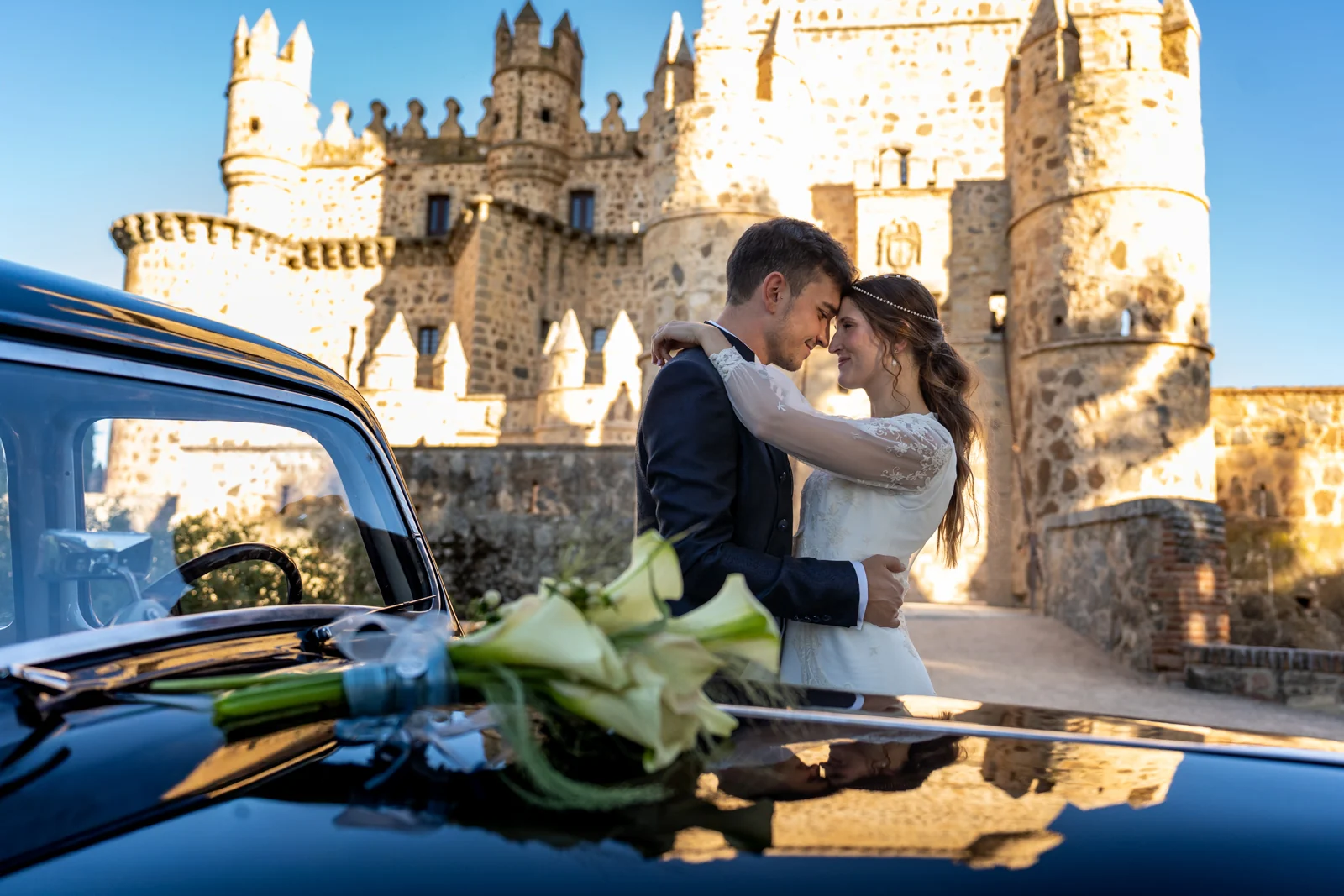 Beso de los novios junto al coche y Castillo de Guadamur
