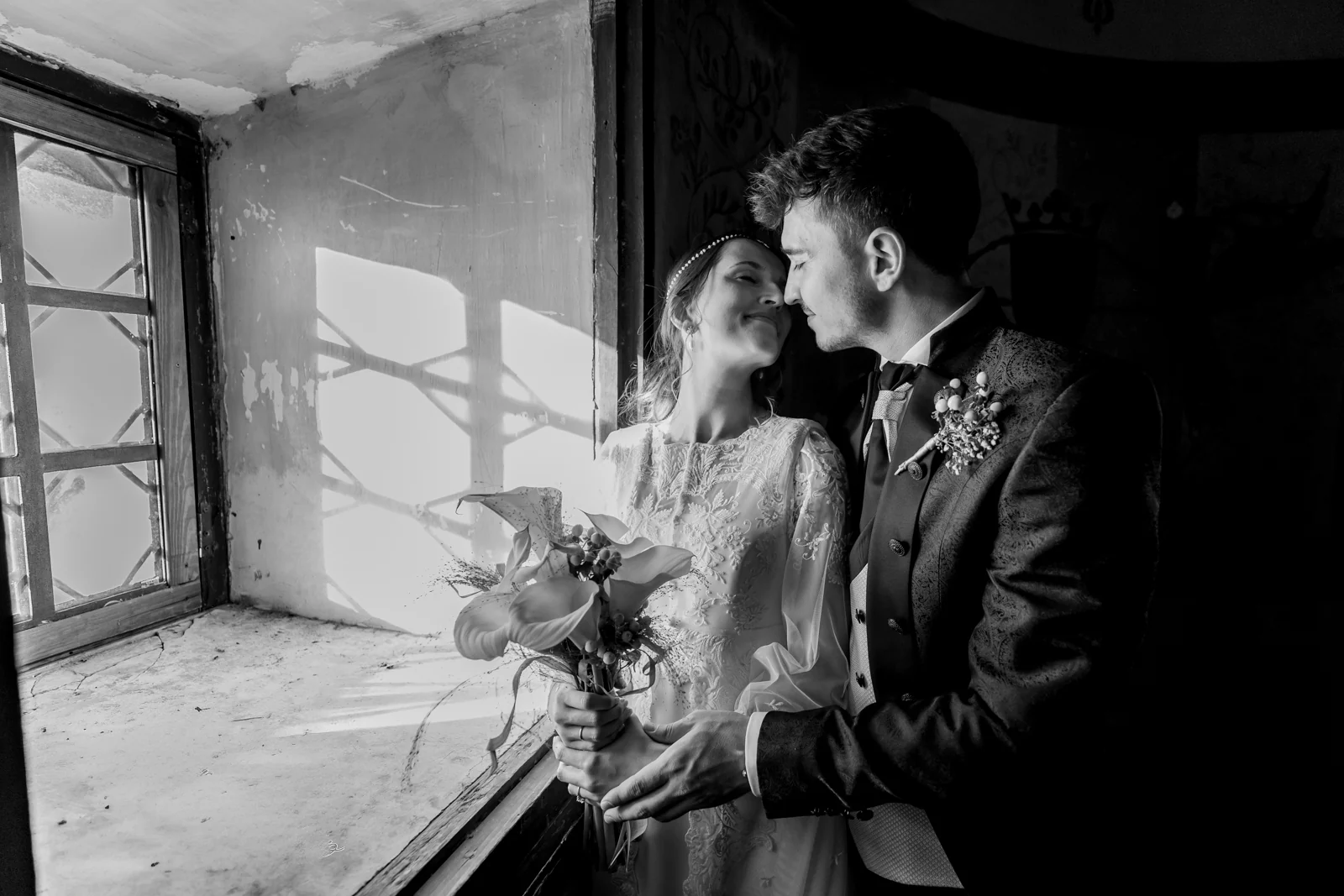 Retrato de los novios junto a una ventana en blanco y negro