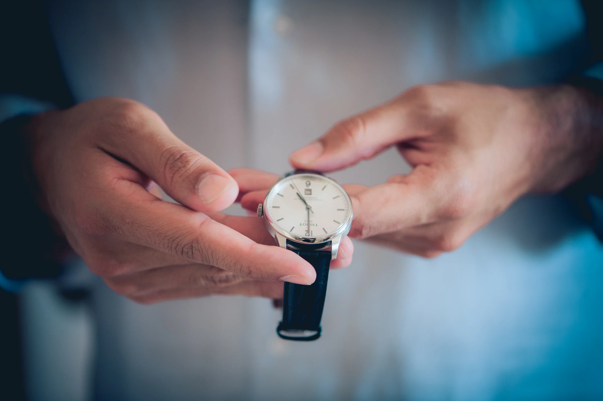 Manos colocando el reloj al novio, fotografía de boda en el Castillo de Viñuelas.