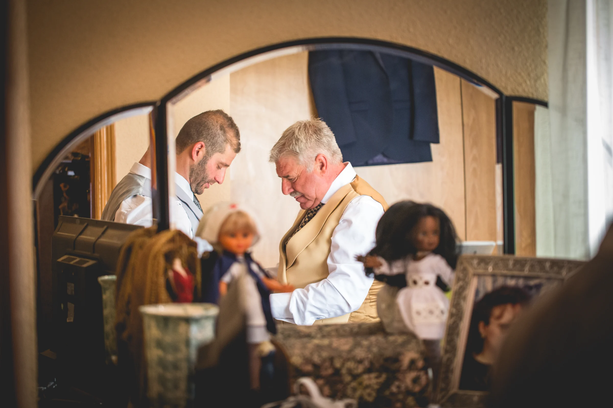 Familiares ayudando al novio a prepararse, fotografía de boda en el Castillo de Viñuelas.