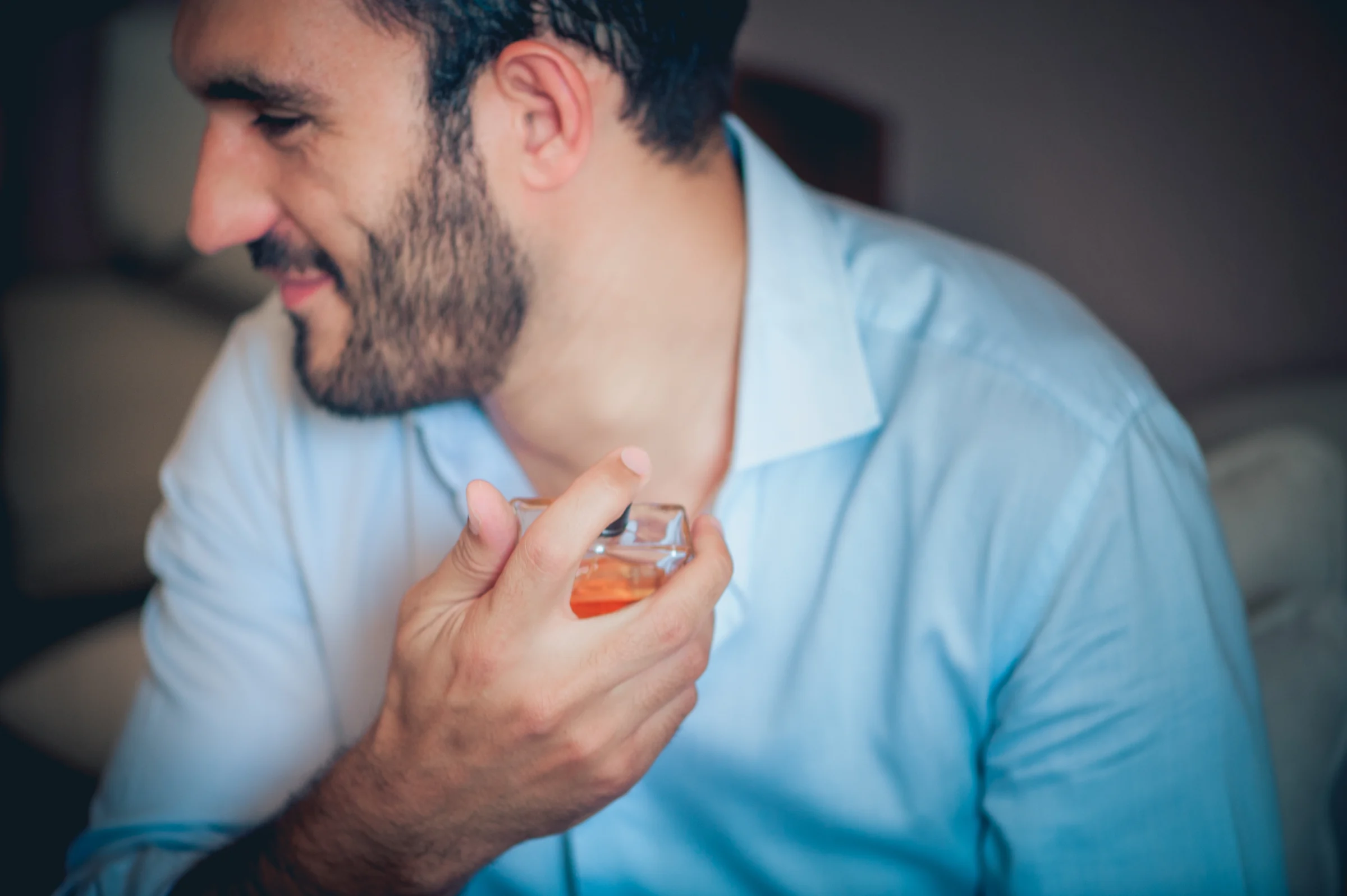 Novio aplicandose perfume antes de la boda, fotografía de boda en el Castillo de Viñuelas.