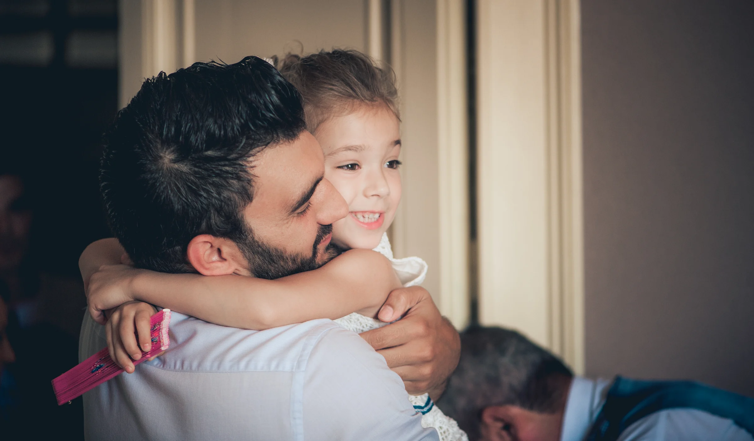 Novio abrazando a una niña durante los preparativos, fotografía de boda en el Castillo de Viñuelas.