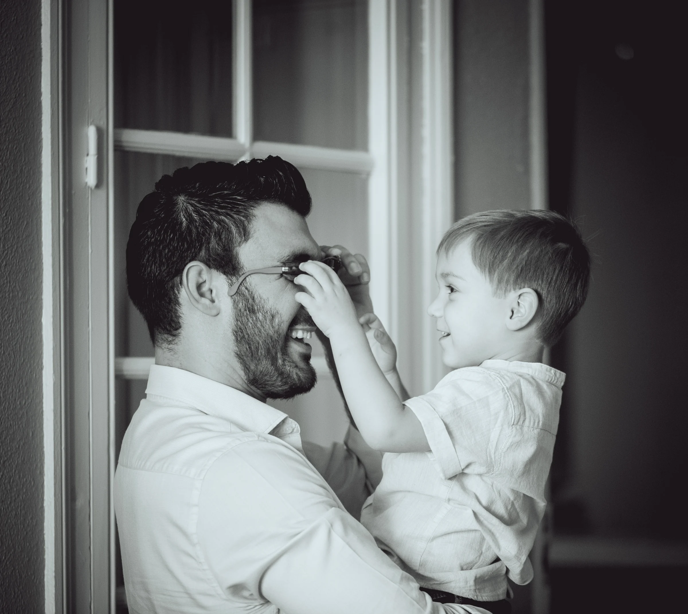 Novio jugando con una niña junto a la ventana, fotografía de boda en el Castillo de Viñuelas.