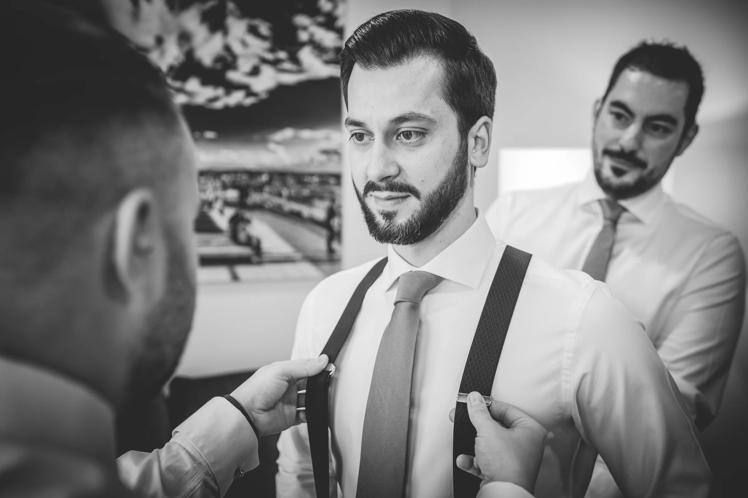 Novio recibiendo ayuda para colocarse la corbata, fotografía de boda en el Castillo de Viñuelas.