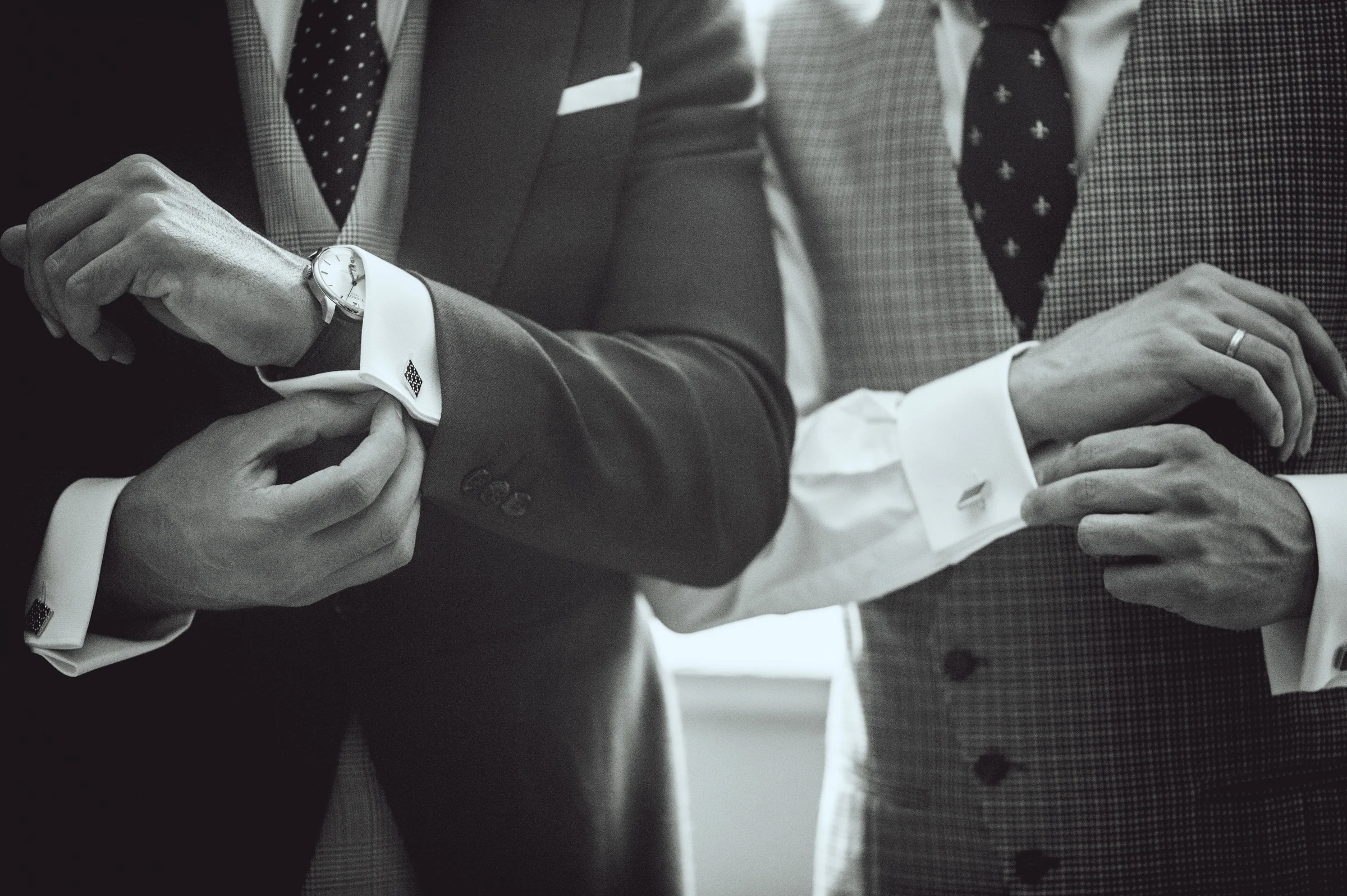 Detalle de las manos ajustando los gemelos del novio, fotografía de boda en el Castillo de Viñuelas.