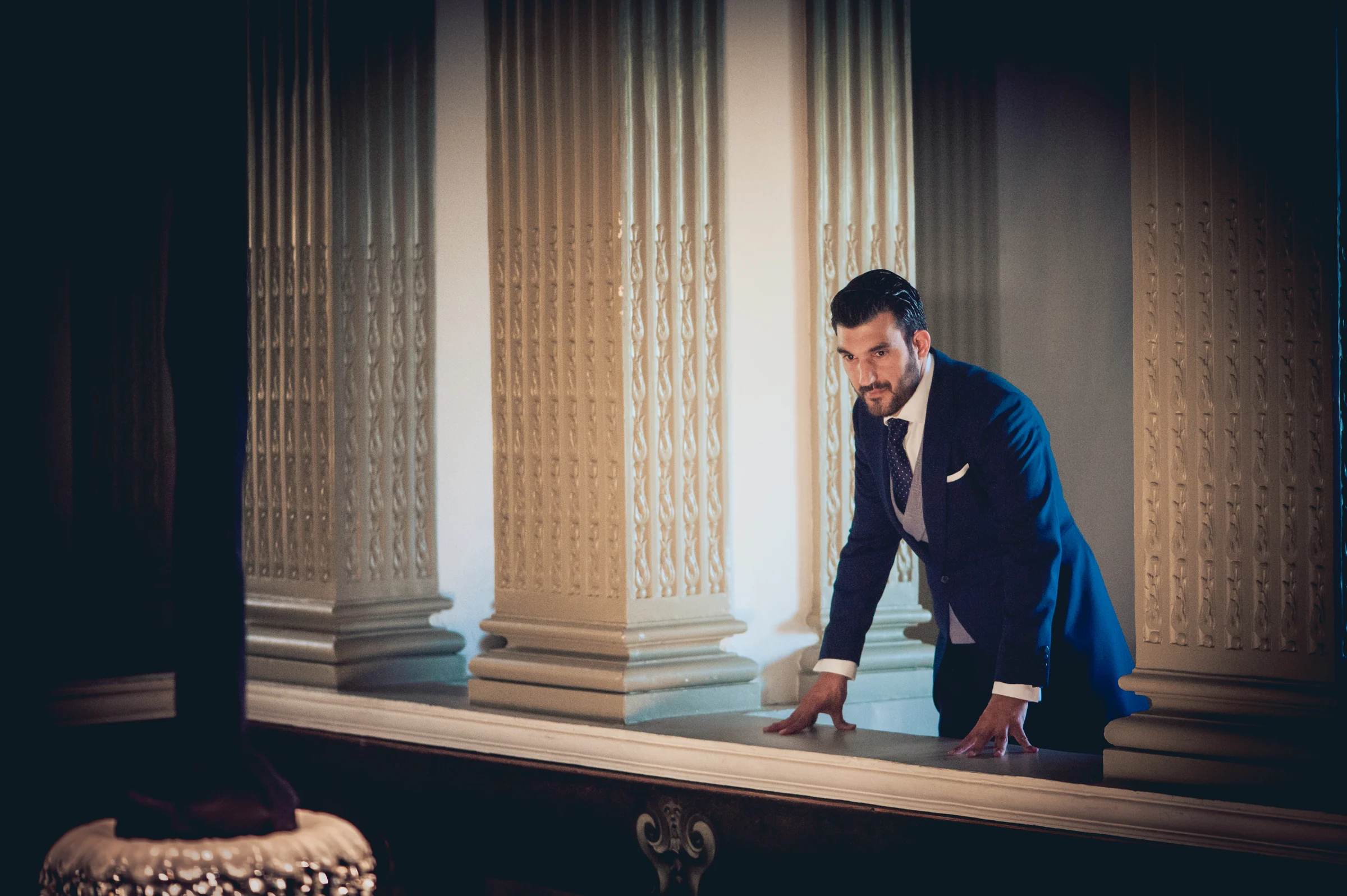 Novio posando junto a las columnas del castillo, fotografía de boda en el Castillo de Viñuelas.