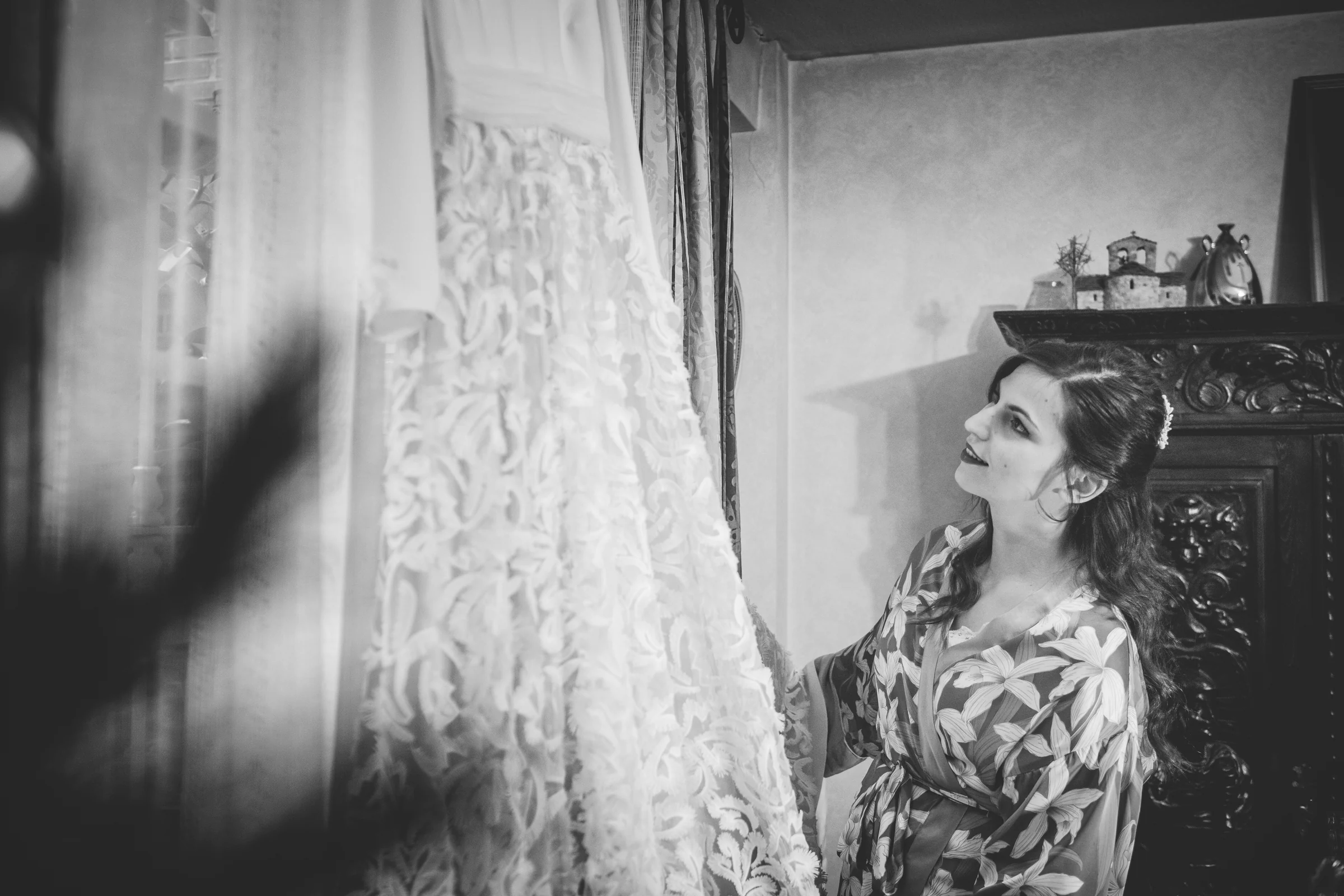 Vestido de novia colgado junto a la ventana, fotografía de boda en el Castillo de Viñuelas.