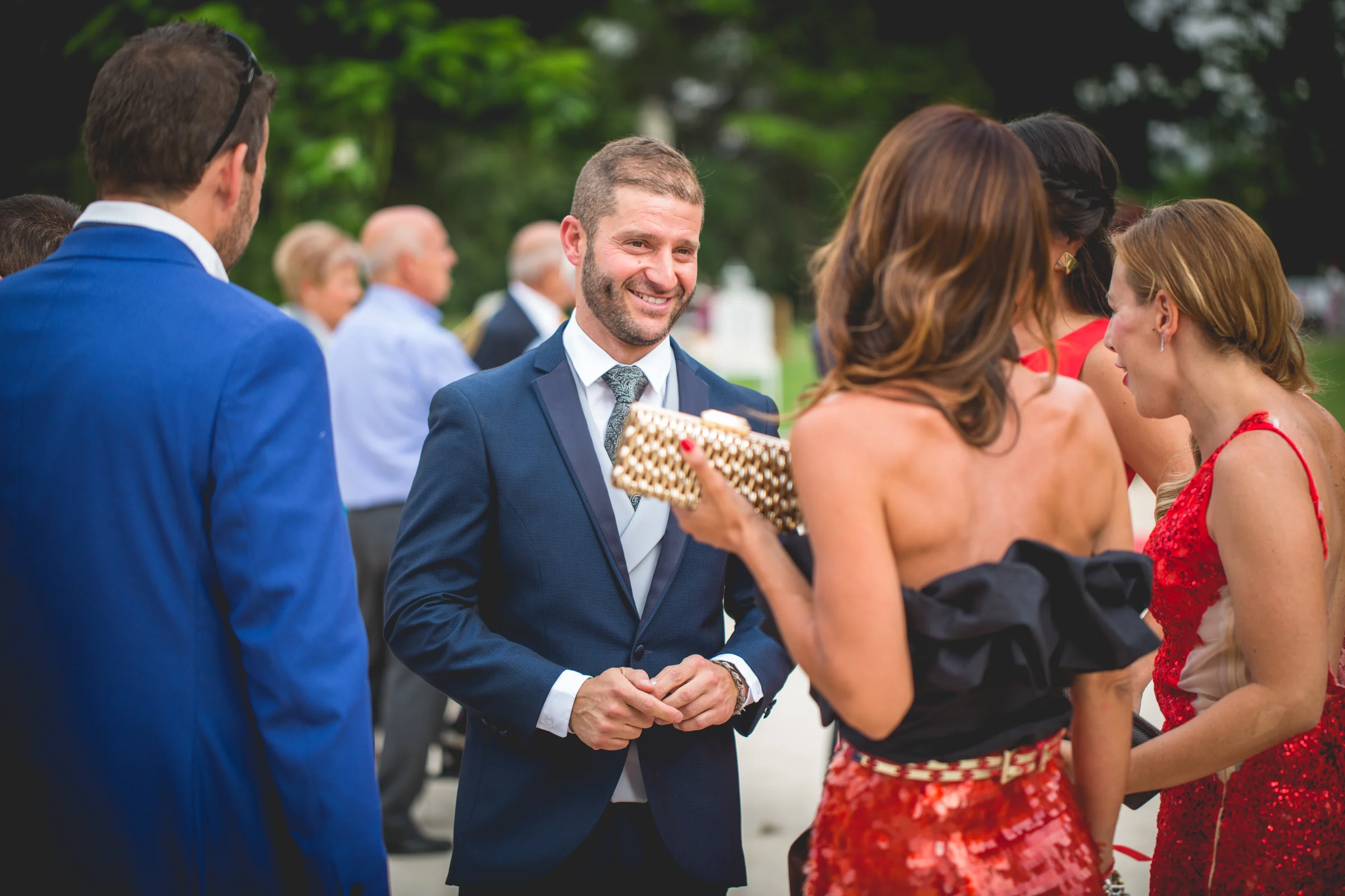 Novio conversando con invitados antes de la ceremonia, fotografía de boda en el Castillo de Viñuelas.