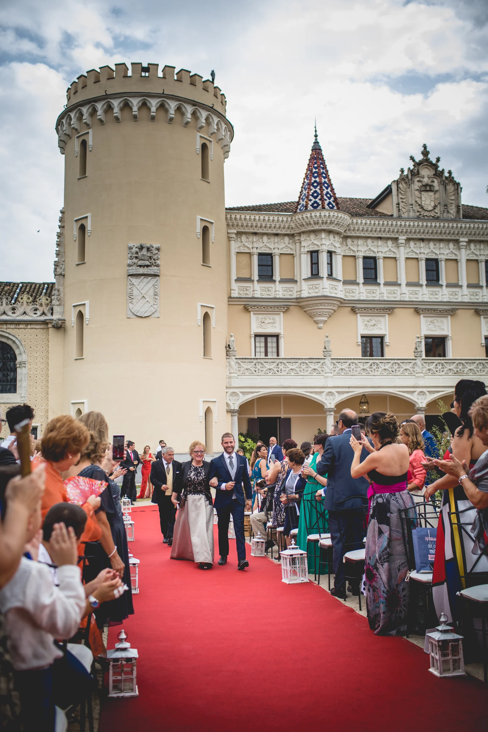 Novia avanzando por la alfombra roja hacia la ceremonia, fotografía de boda en el Castillo de Viñuelas.