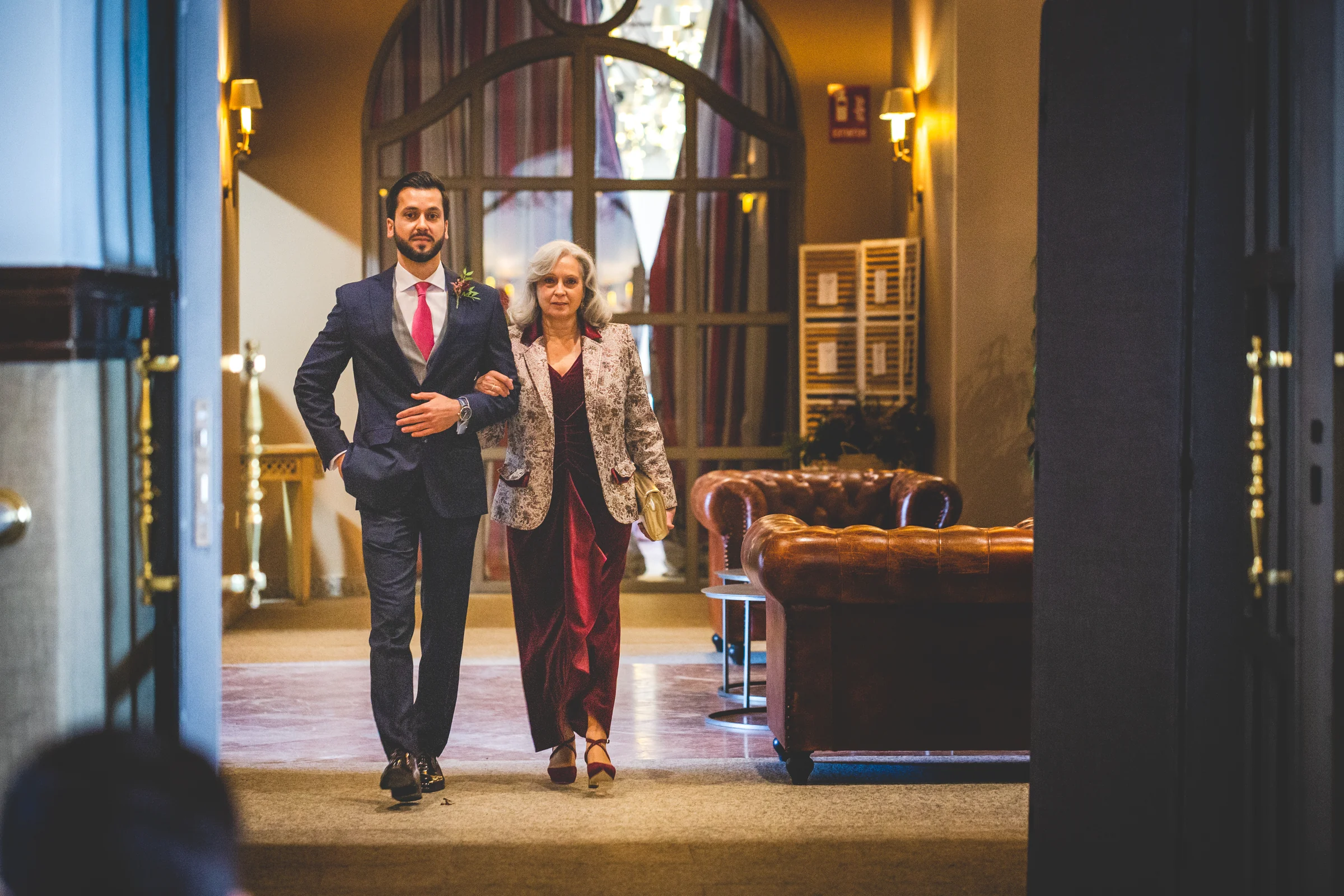 Novio entrando acompañado por su madre, fotografía de boda en el Castillo de Viñuelas.
