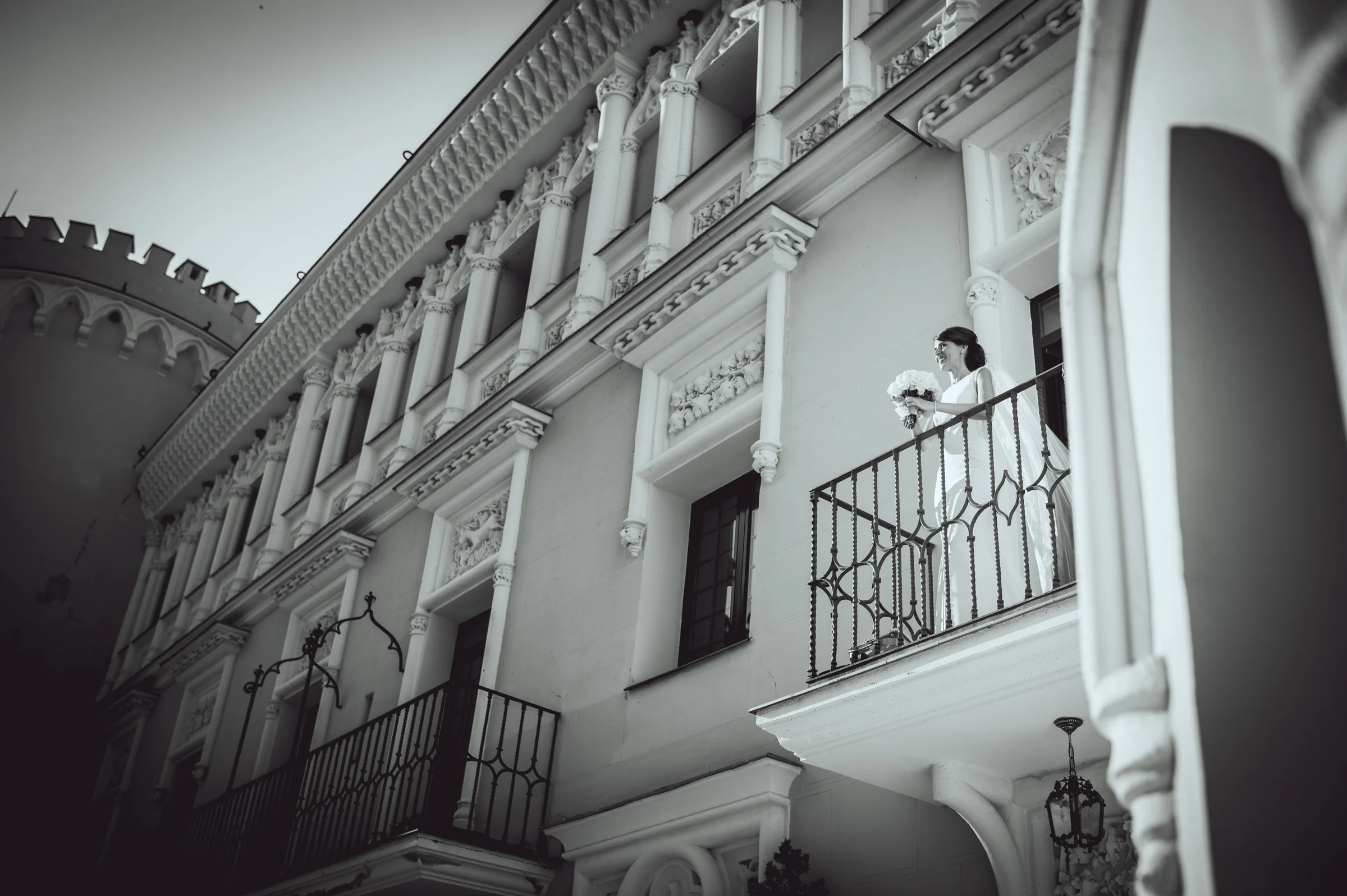 Pareja asomada a un balcón del castillo de Viñuelas, fotografía de boda en el Castillo de Viñuelas.