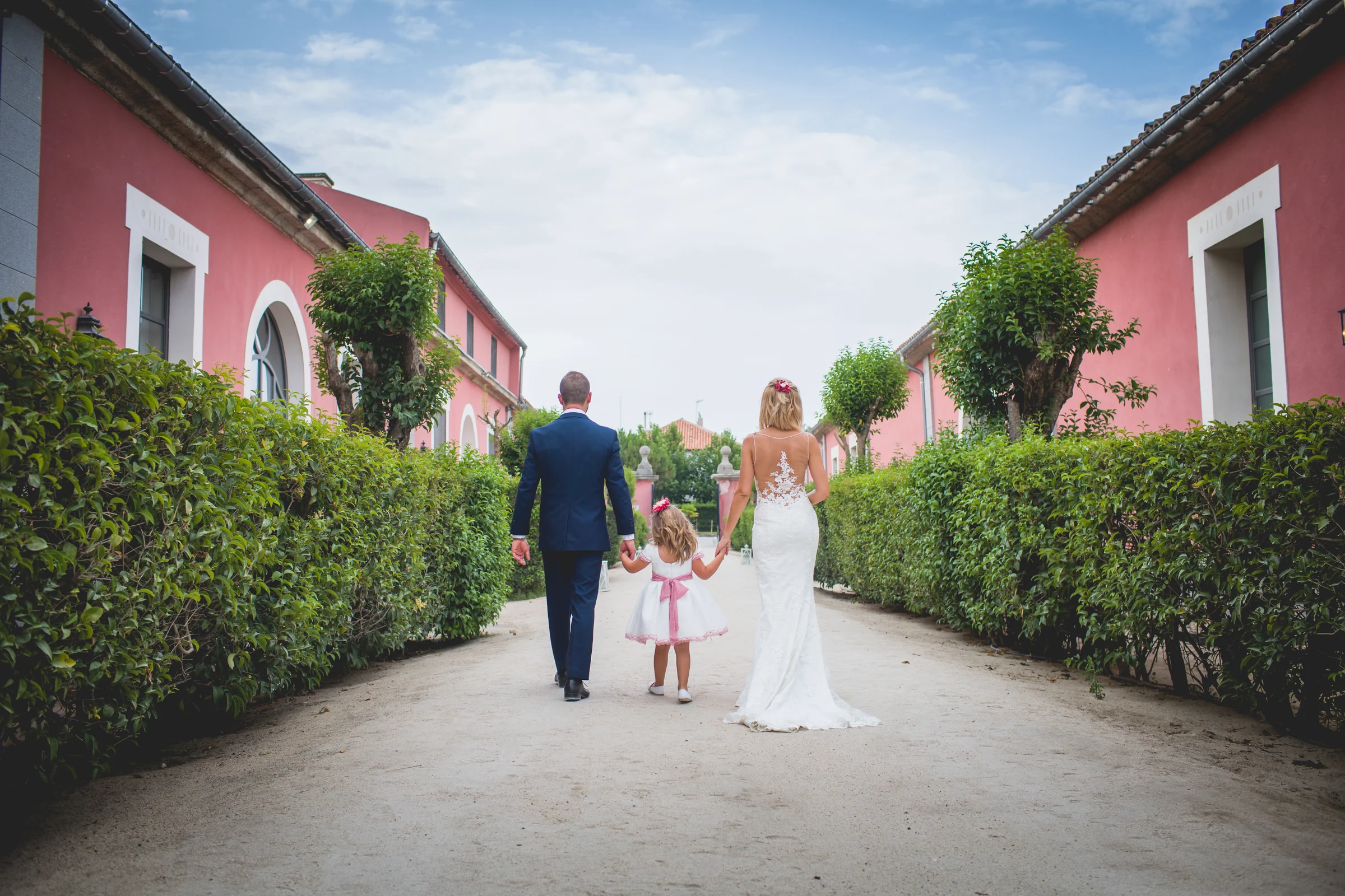 Novia caminando por el jardín con familiares y niños, fotografía de boda en el Castillo de Viñuelas.
