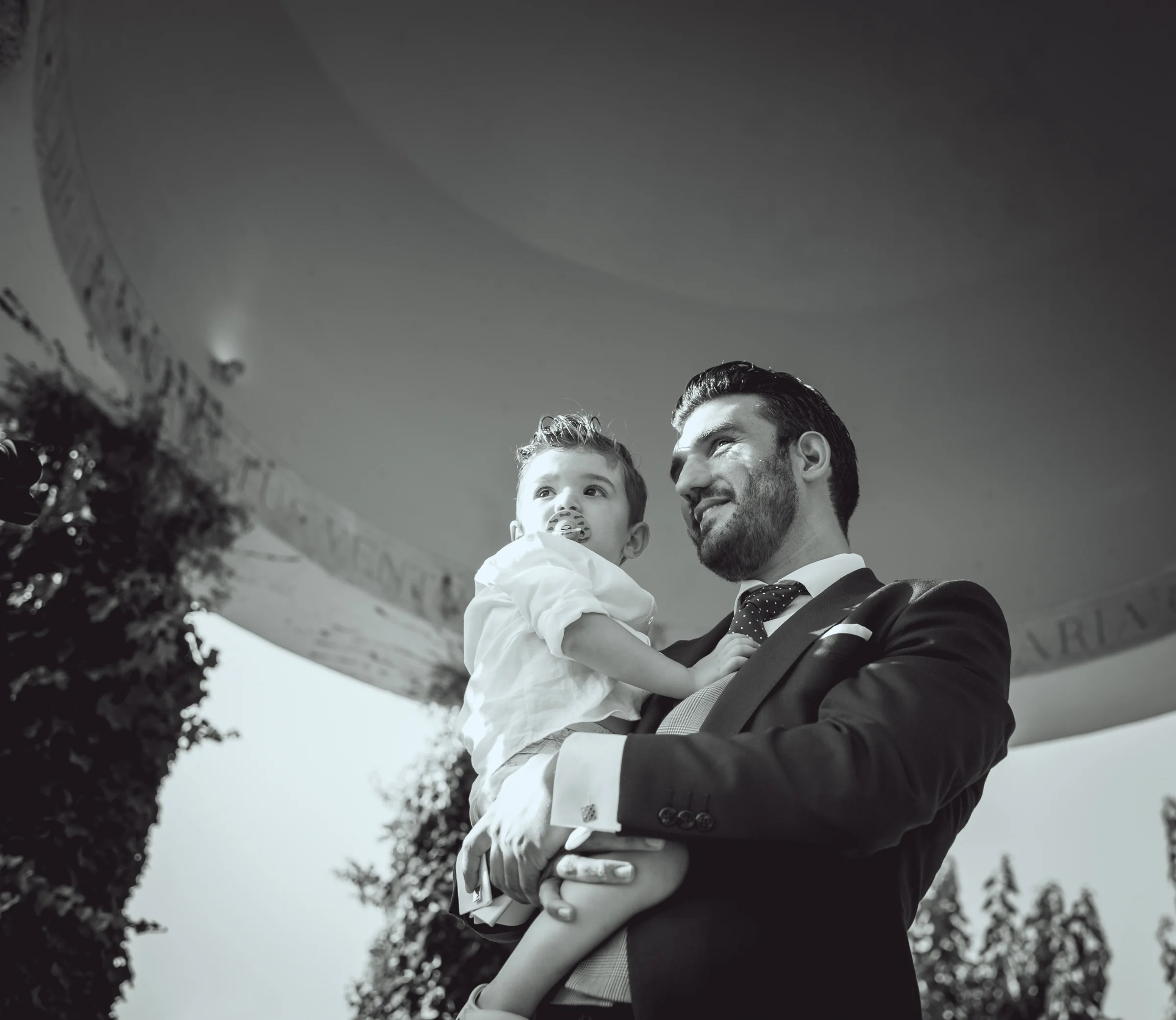 Novio sosteniendo a una niña durante la ceremonia, fotografía de boda en el Castillo de Viñuelas.