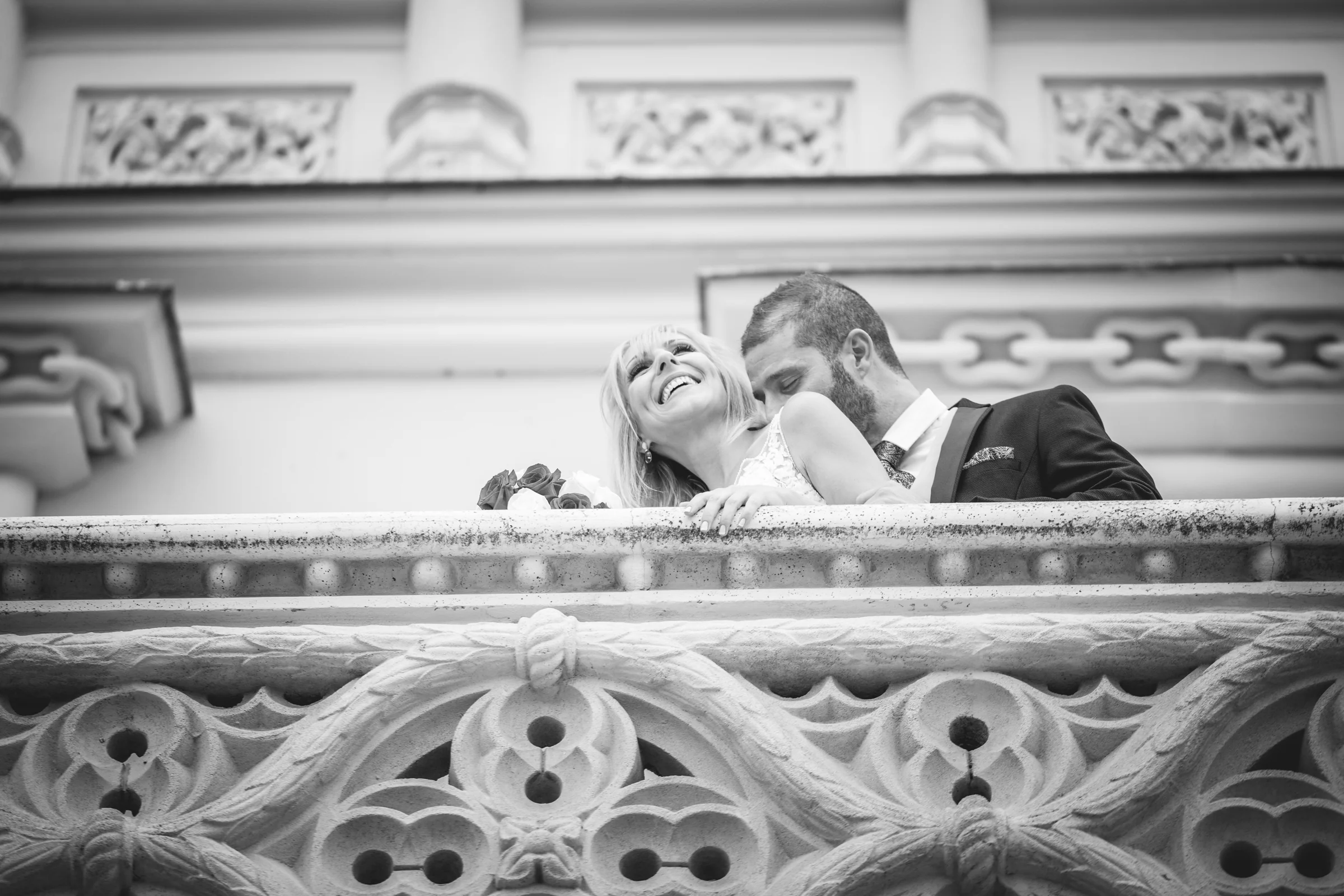 Novios besándose en un balcón de piedra del castillo, fotografía de boda en el Castillo de Viñuelas.