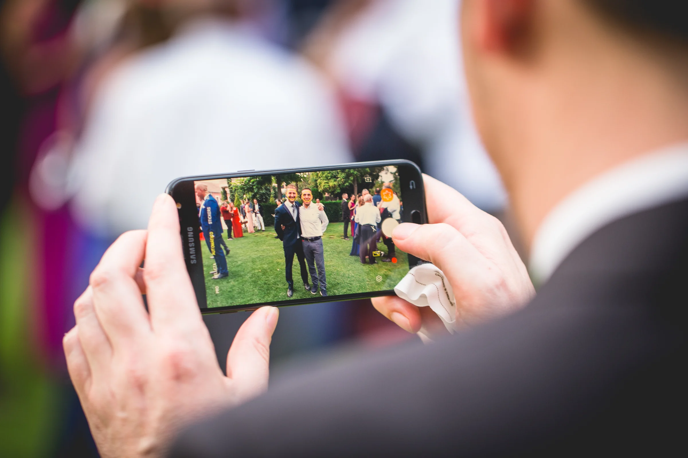 Invitado fotografiando con el móvil durante la boda, fotografía de boda en el Castillo de Viñuelas.