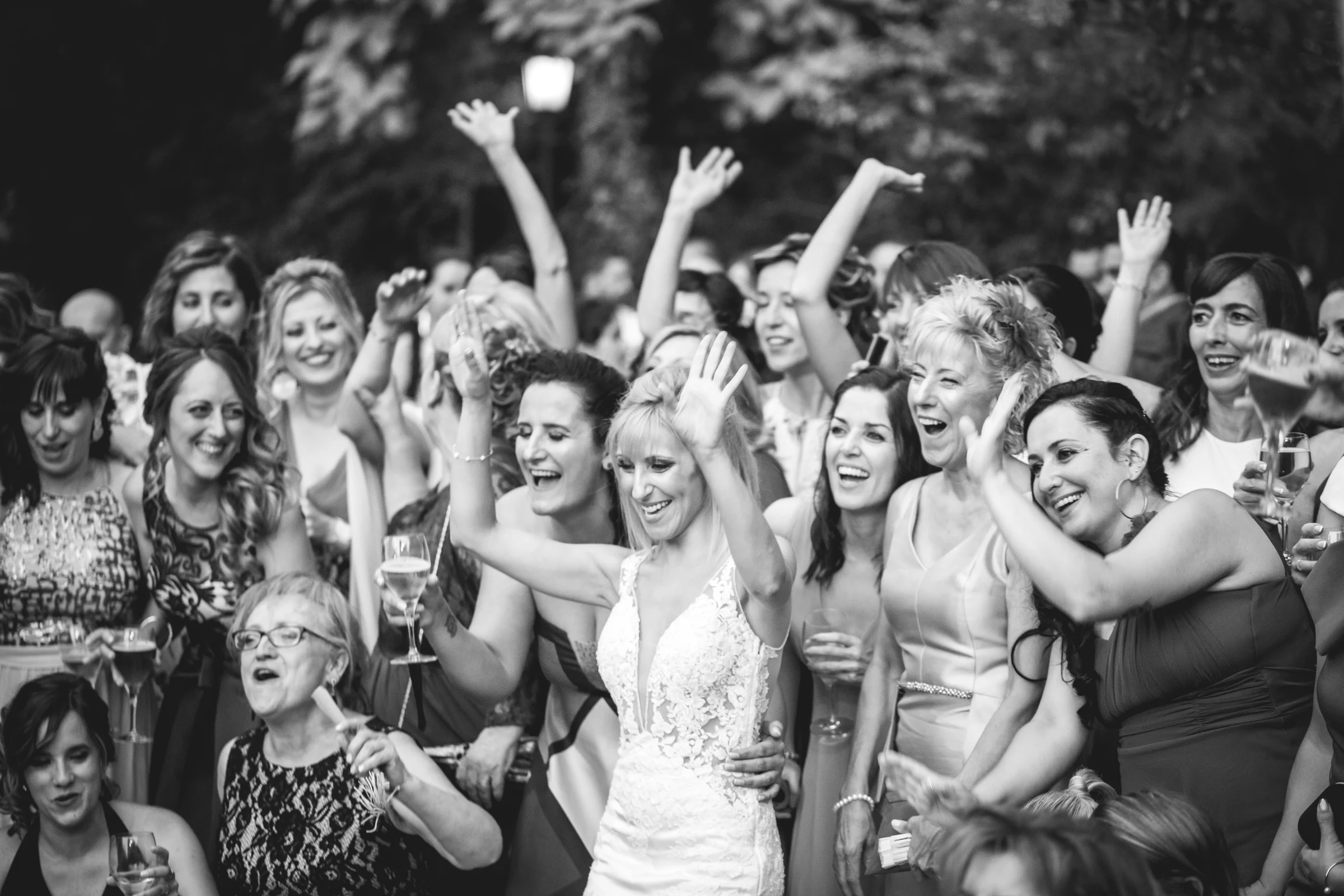 Grupo de invitadas celebrando y levantando los brazos, fotografía de boda en el Castillo de Viñuelas.