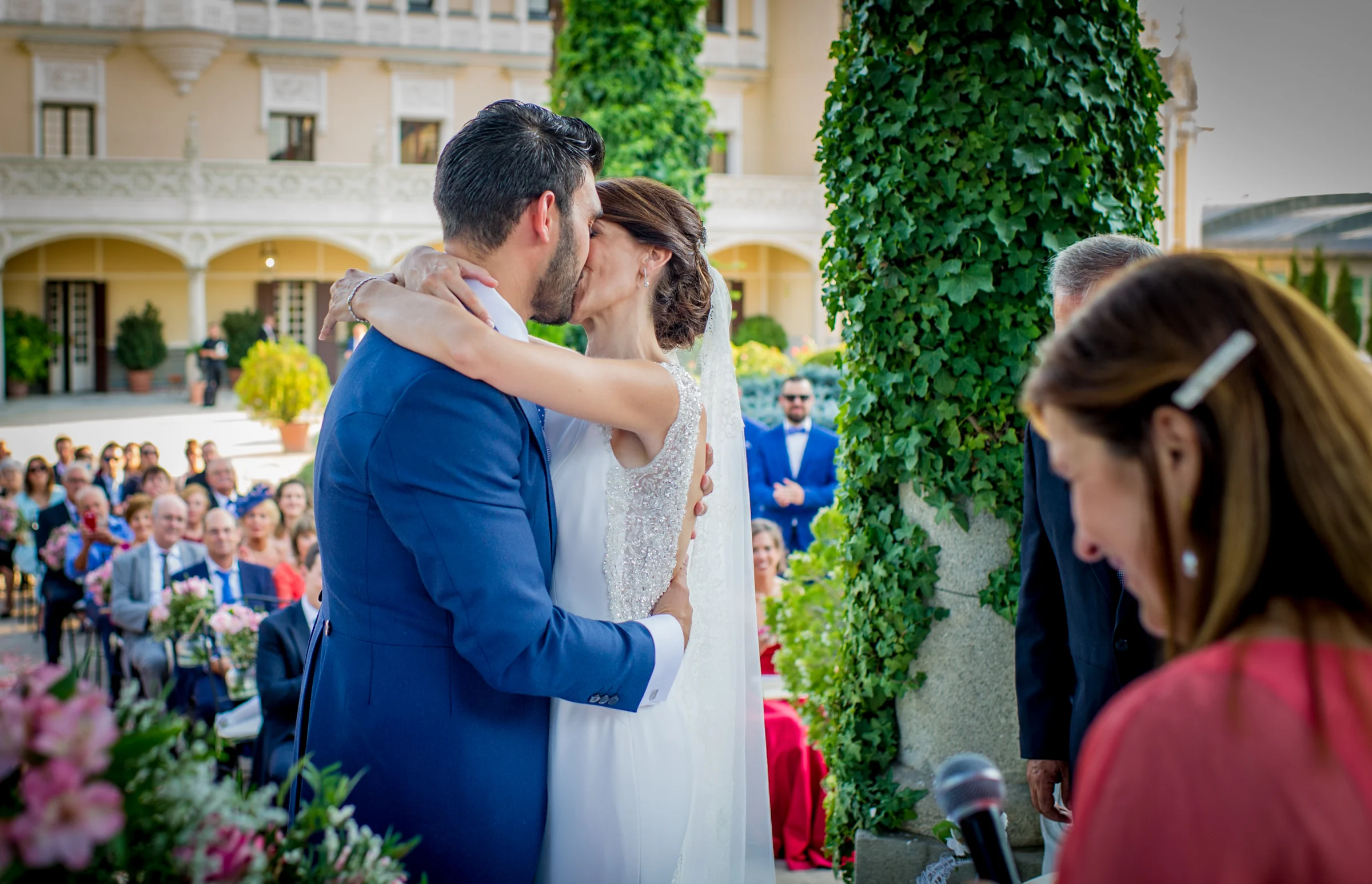 Beso de los novios frente a los invitados, fotografía de boda en el Castillo de Viñuelas.
