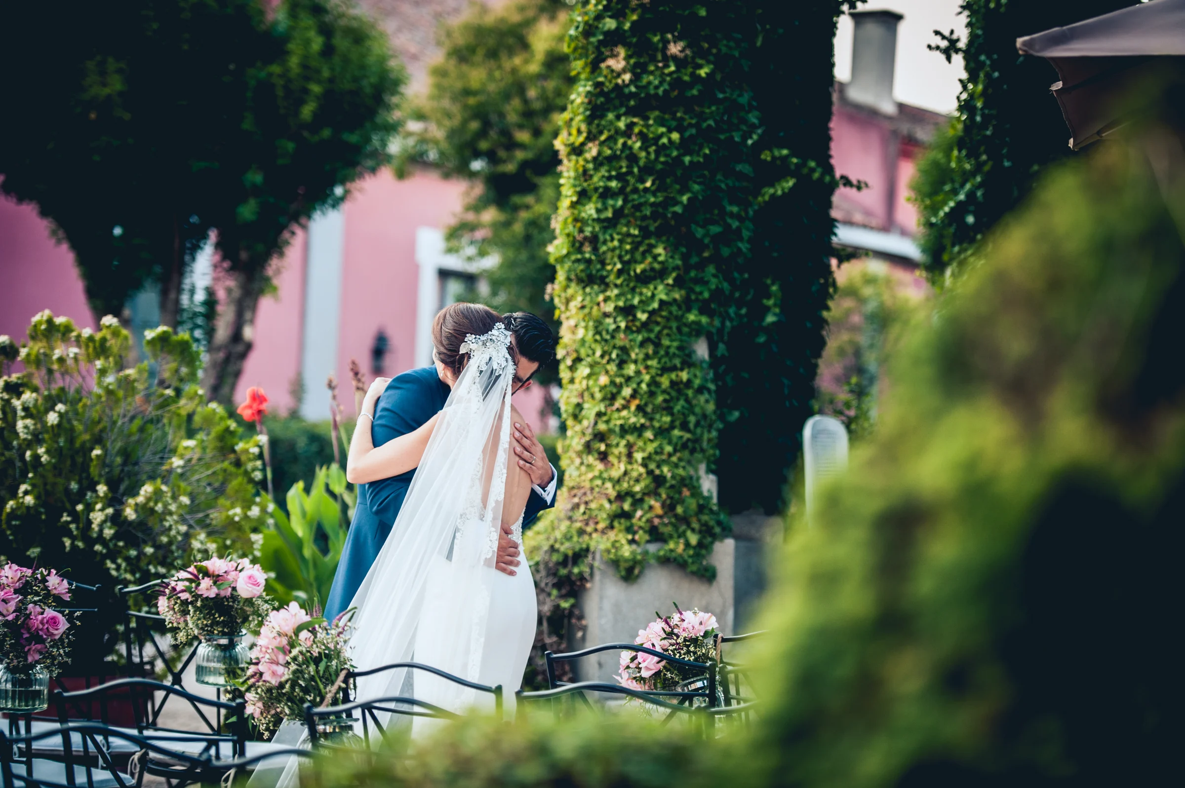 Novios besándose junto a un seto del jardín, fotografía de boda en el Castillo de Viñuelas.
