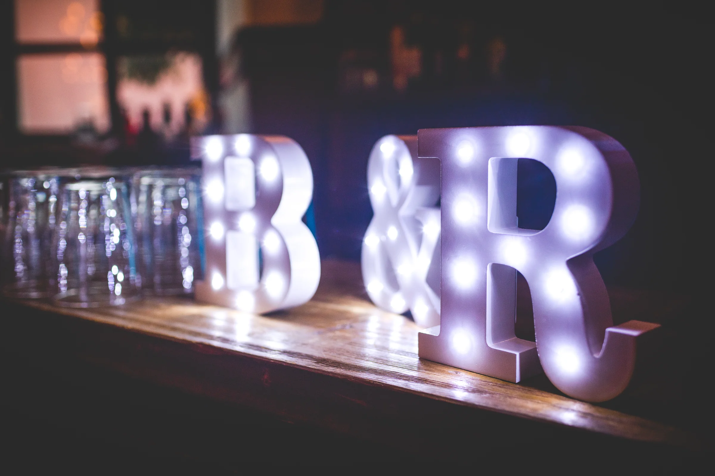 Iniciales luminosas de los novios en la barra, fotografía de boda en el Castillo de Viñuelas.