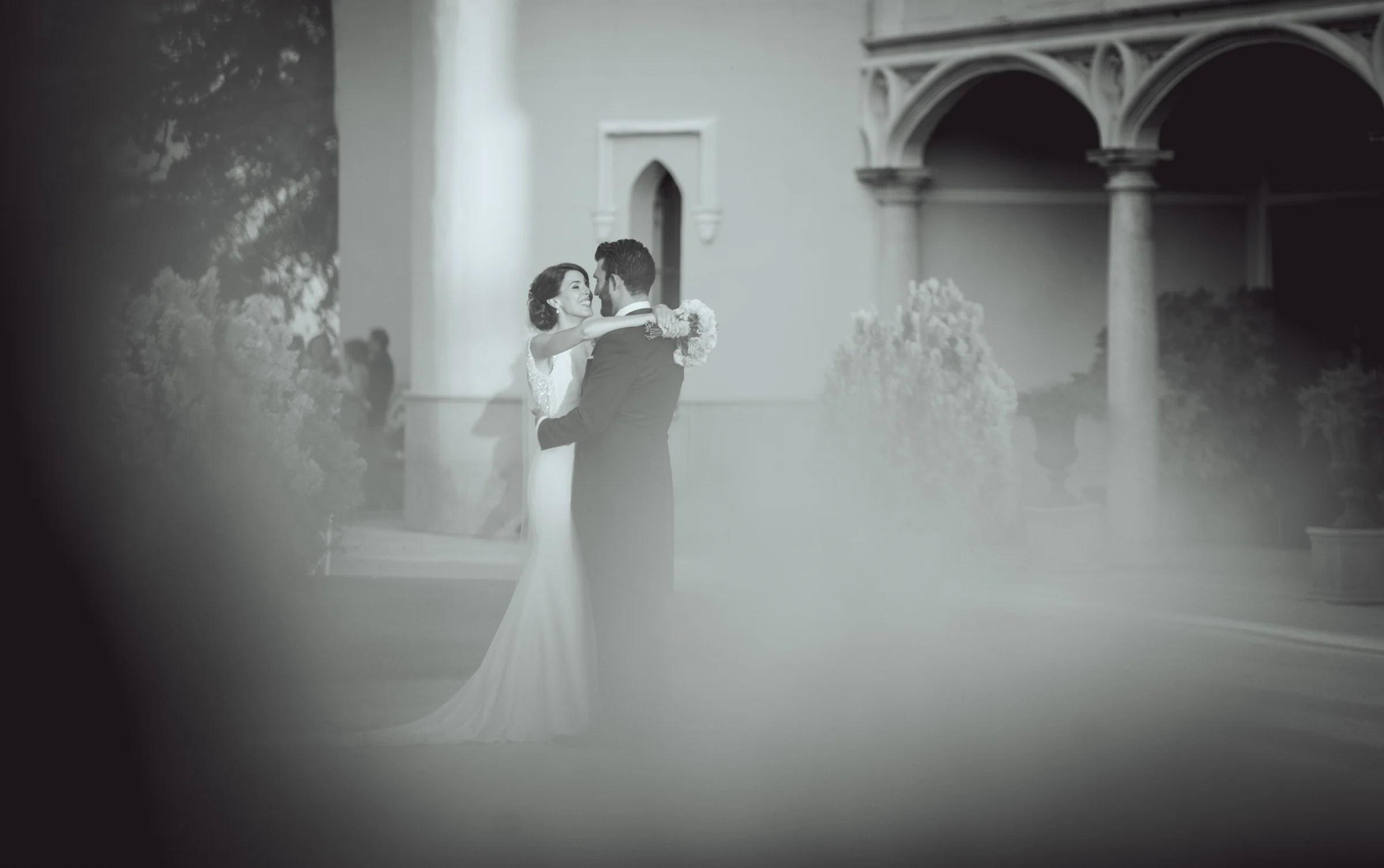 Novios retratados entre la vegetacion del jardín, fotografía de boda en el Castillo de Viñuelas.