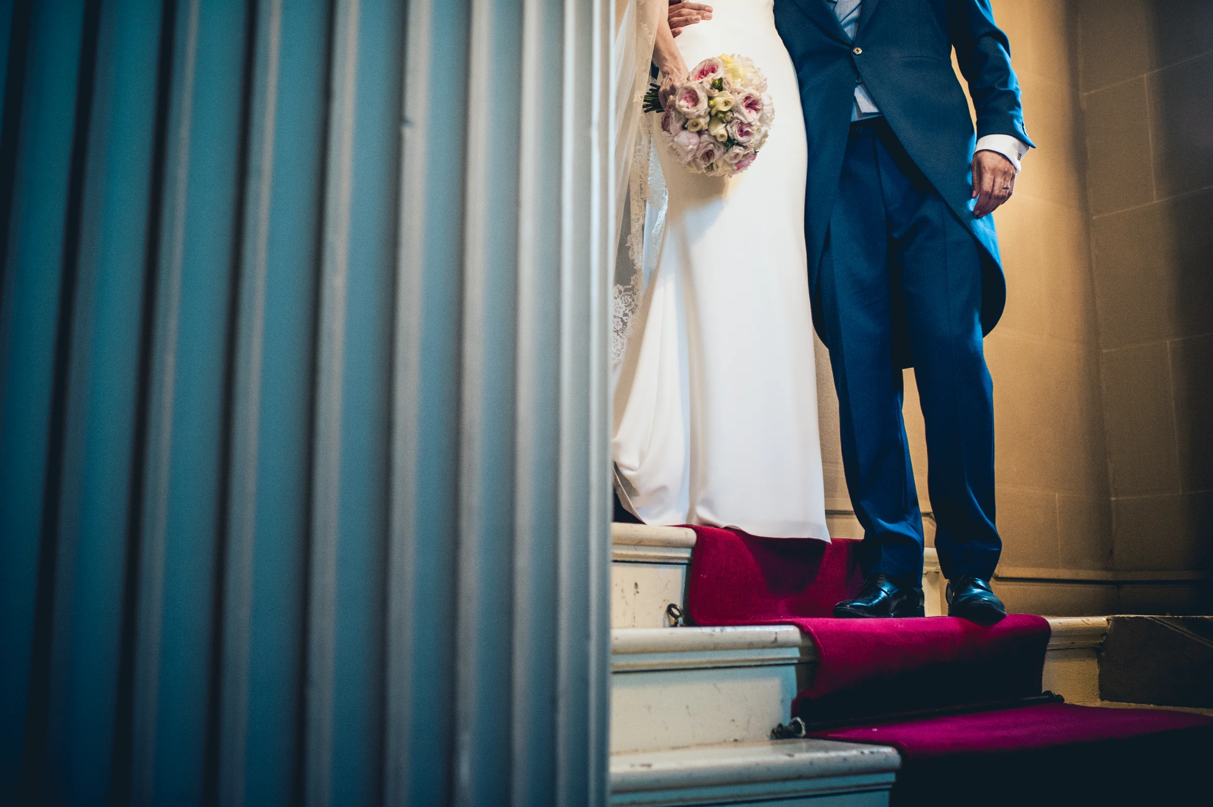 Detalle de los novios bajando los escalones, fotografía de boda en el Castillo de Viñuelas.
