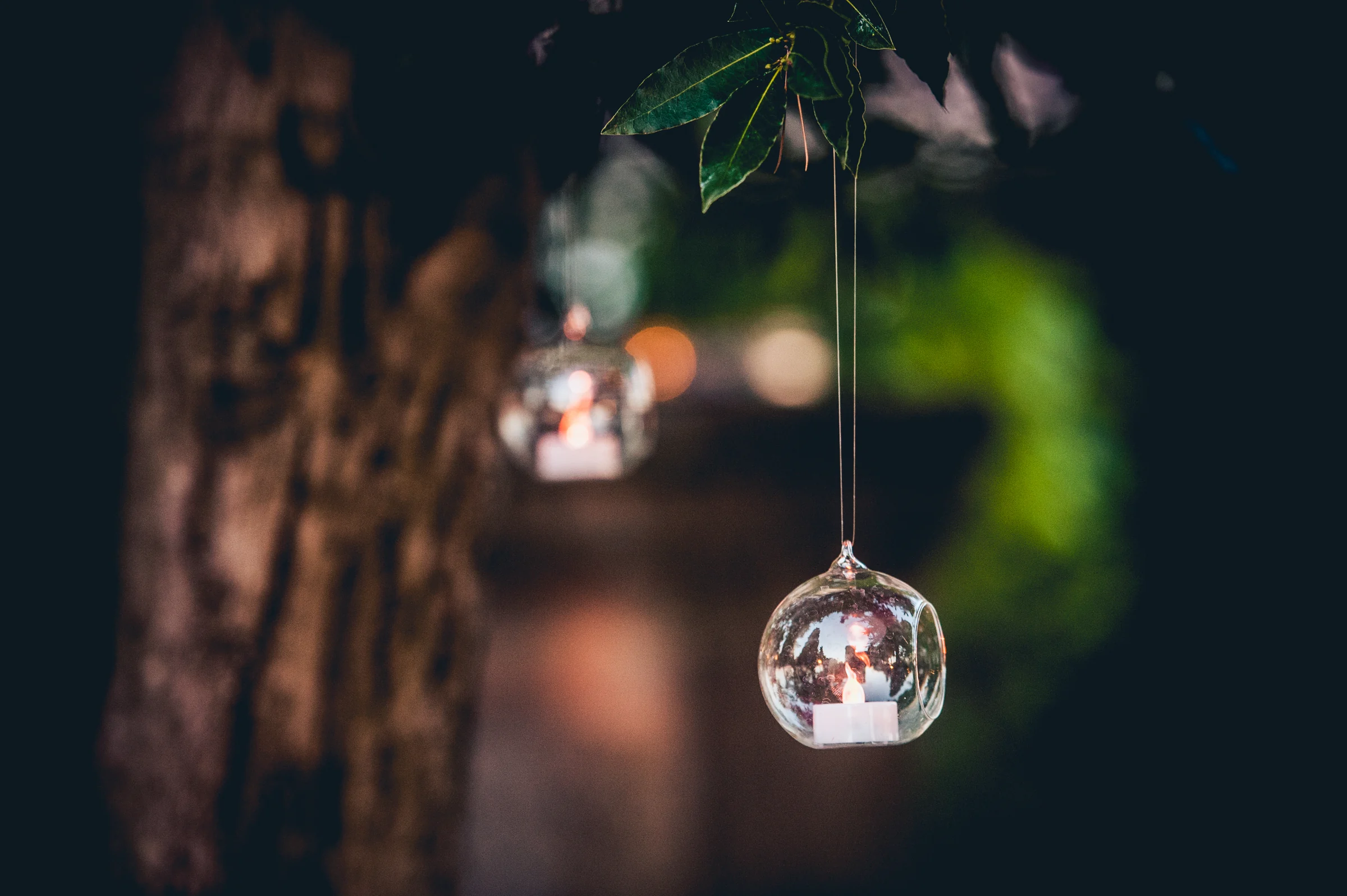 Detalle de una bola de cristal decorativa colgada de un arbol, fotografía de boda en el Castillo de Viñuelas.