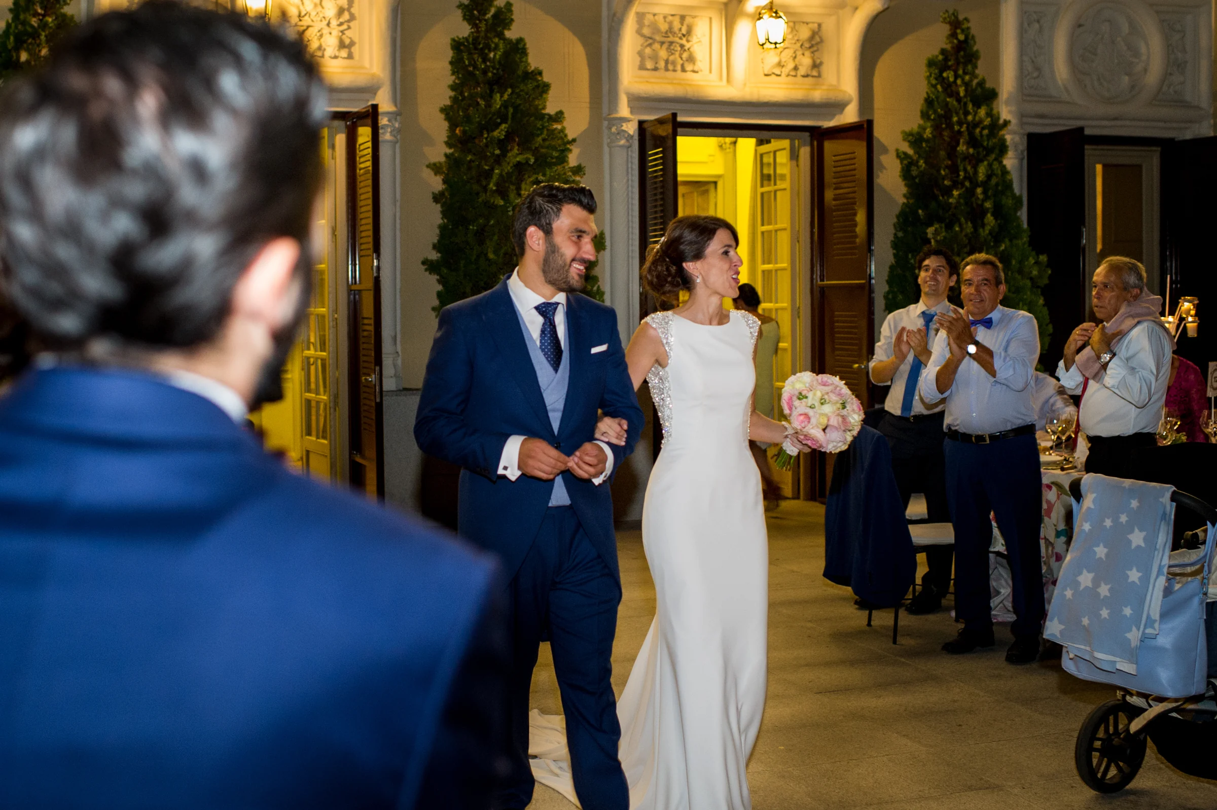 Entrada de los novios al banquete entre aplausos, fotografía de boda en el Castillo de Viñuelas.
