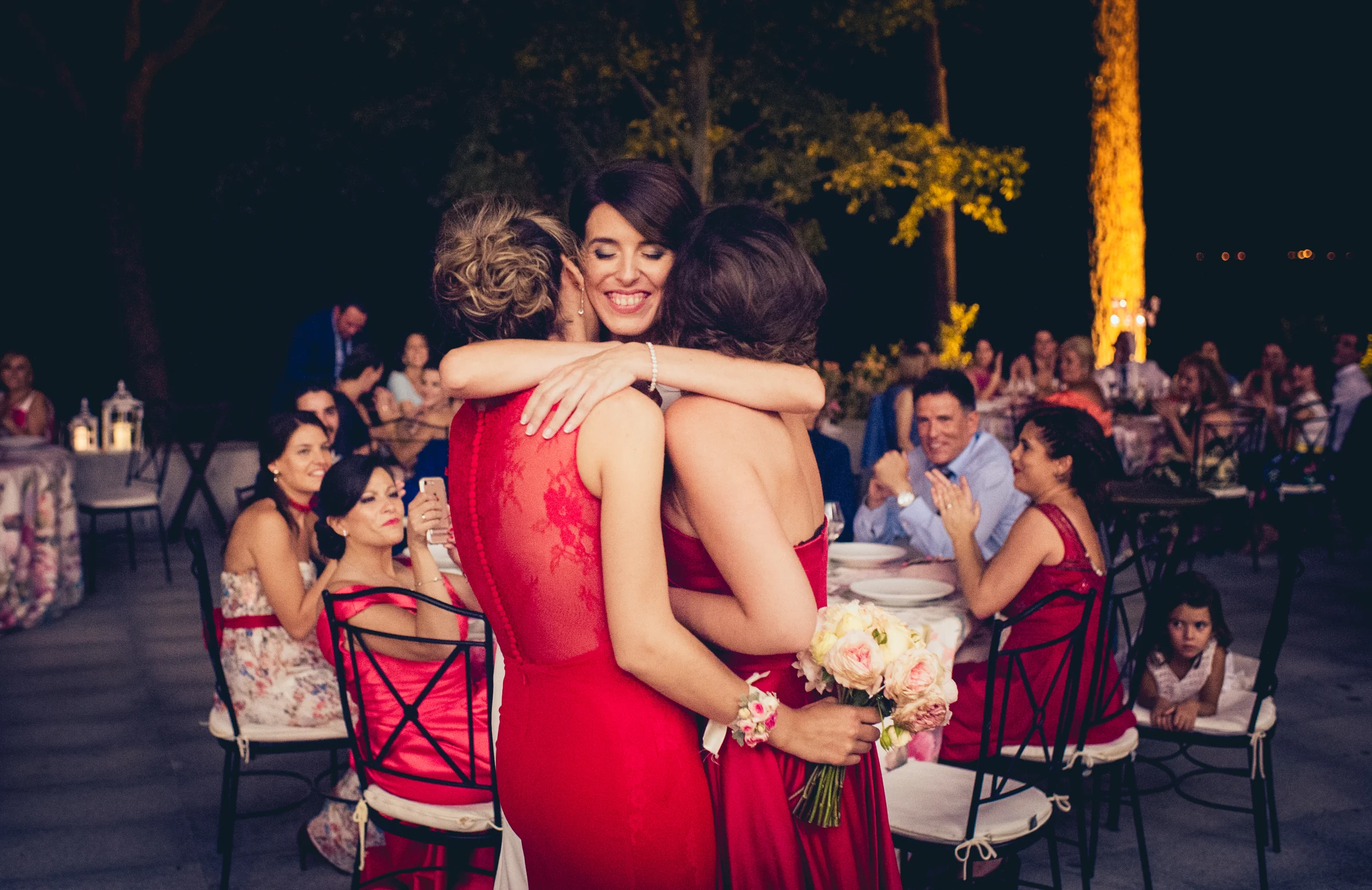 Novia abrazando a sus amigas durante la celebración, fotografía de boda en el Castillo de Viñuelas.