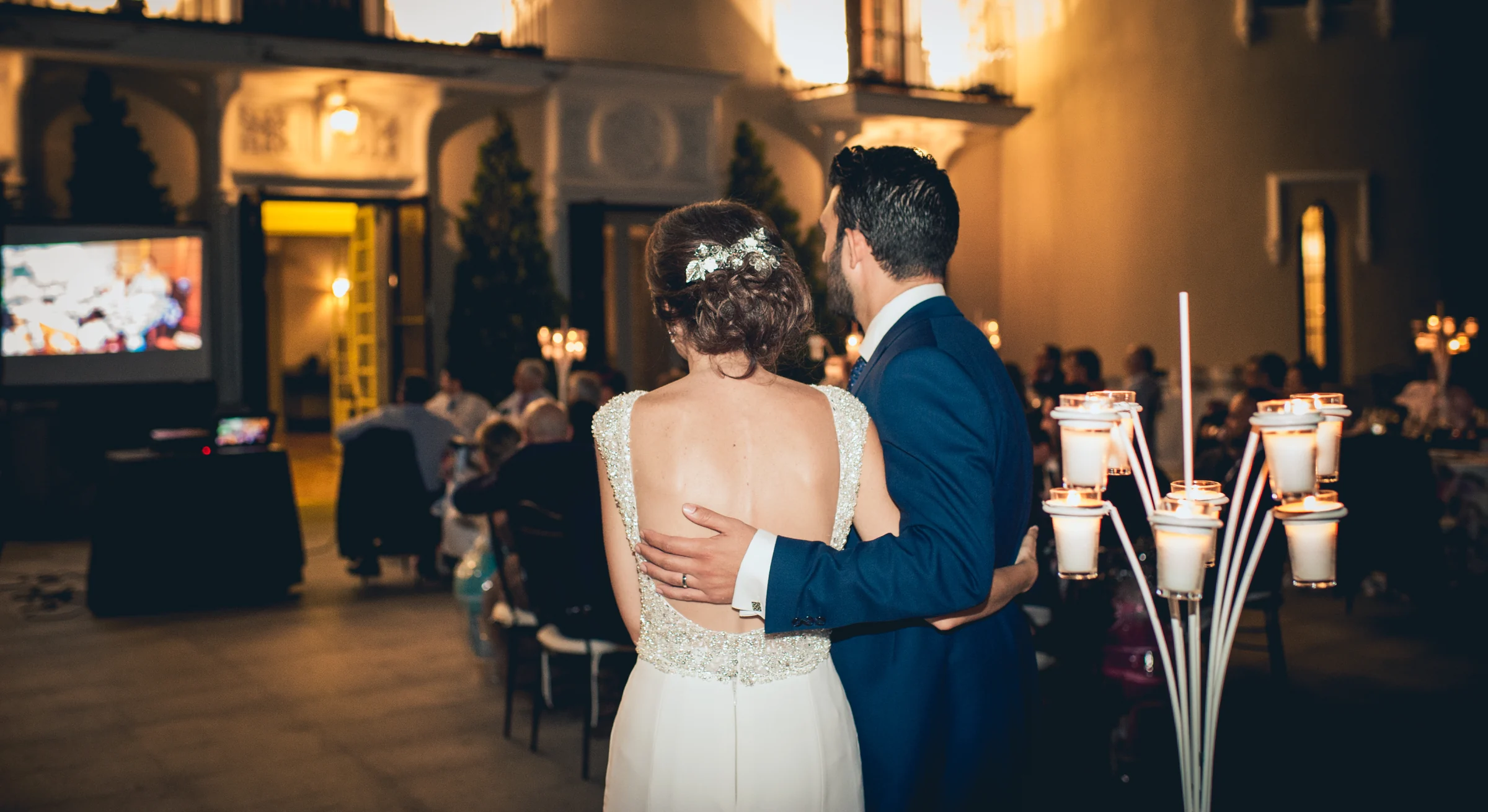 Novios observando la celebración desde el salon, fotografía de boda en el Castillo de Viñuelas.