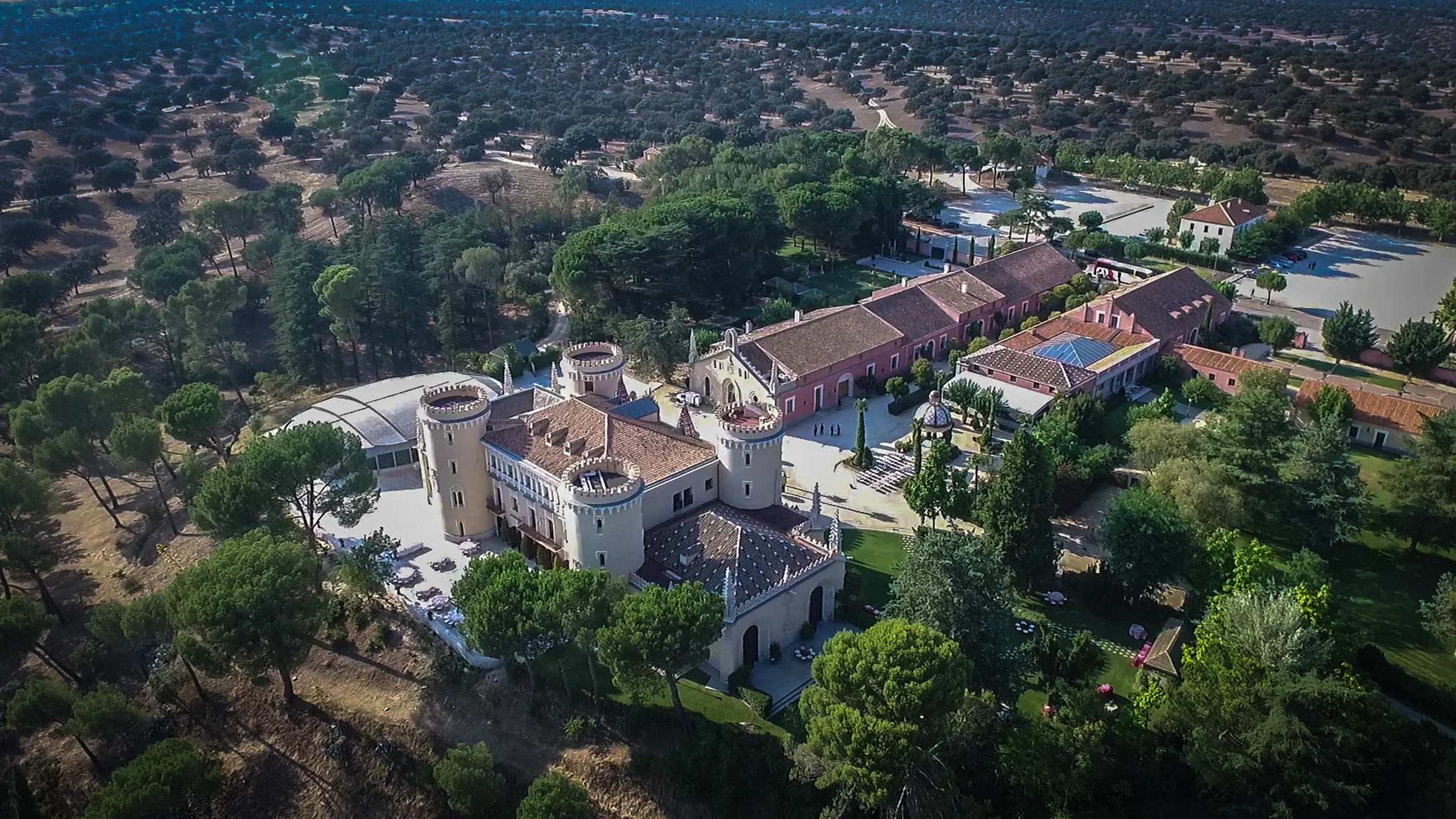Panorámica aérea del recinto del Castillo de Viñuelas rodeado de vegetación y espacios para bodas.