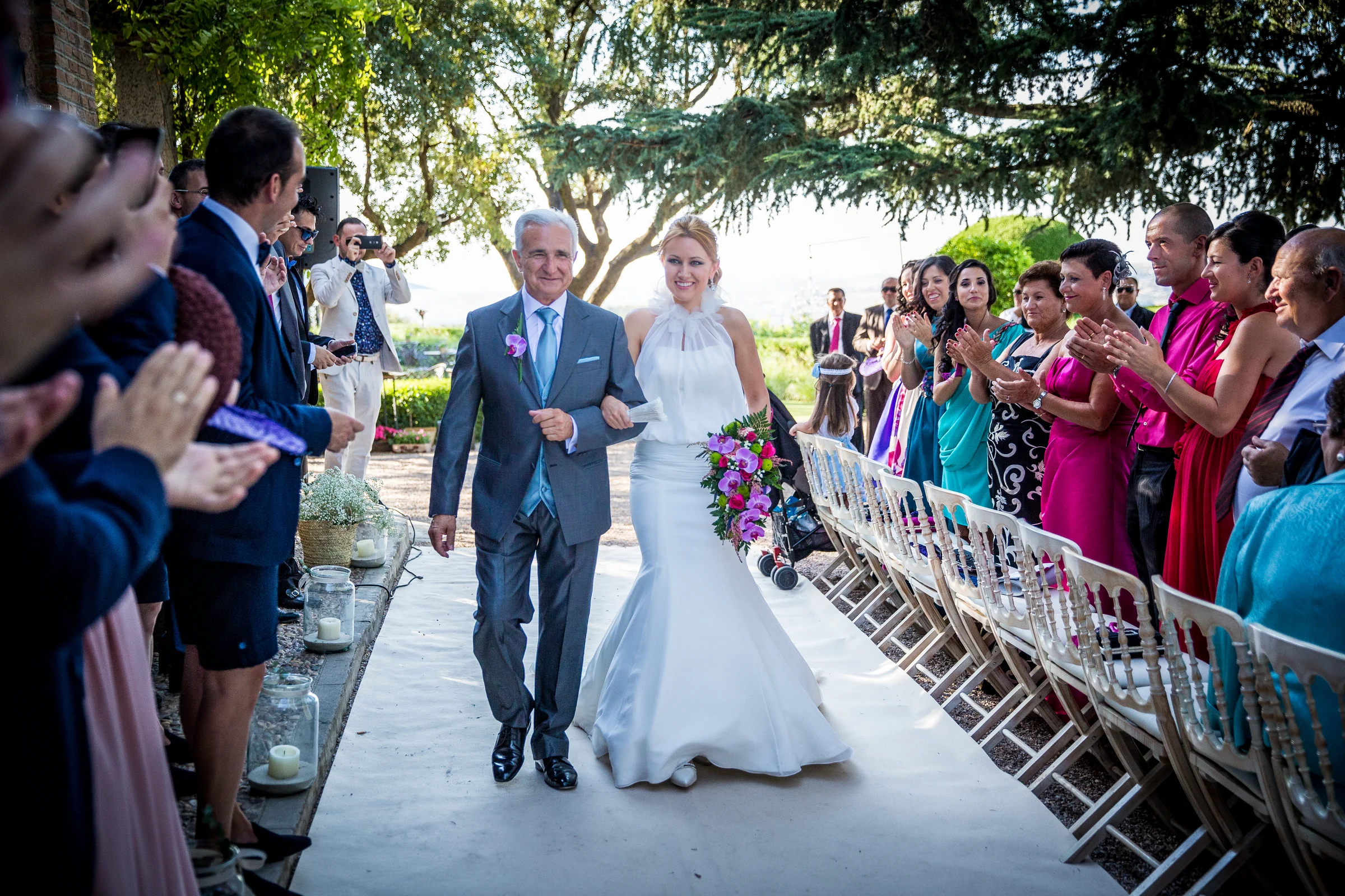 Novia entrando a la ceremonia entre los invitados en Cigarral de las Mercedes.