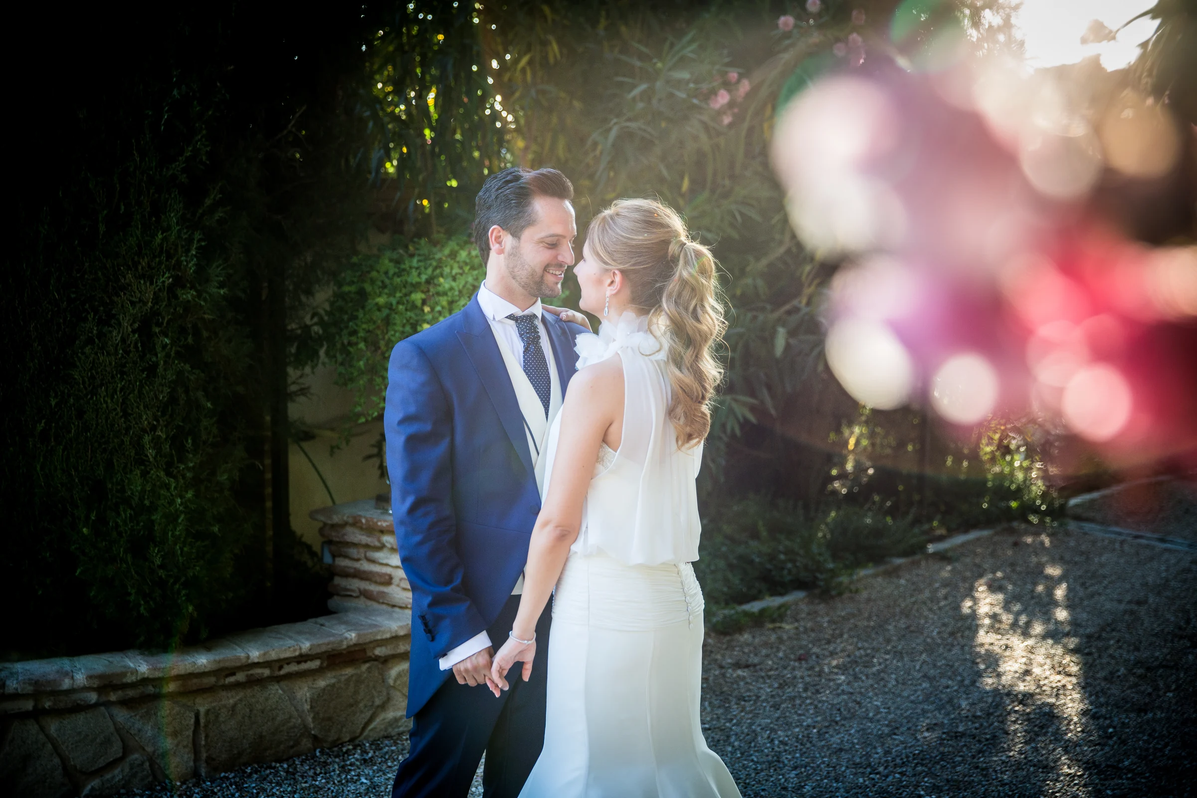 Novios retratados con luz de atardecer en los jardines de Cigarral de las Mercedes.