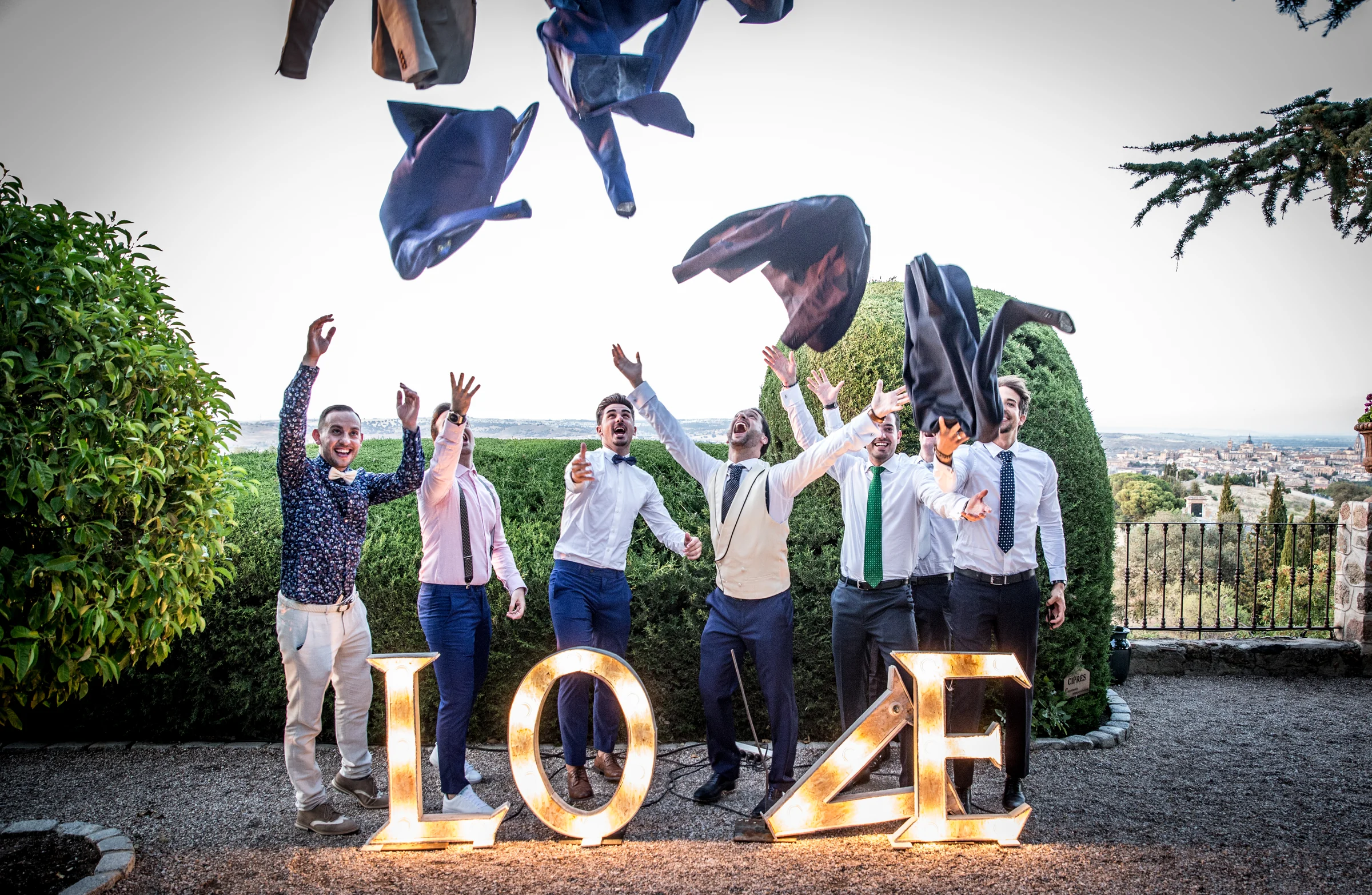 Amigos del novio celebrando junto a letras LOVE con vistas de Toledo desde Cigarral de las Mercedes.