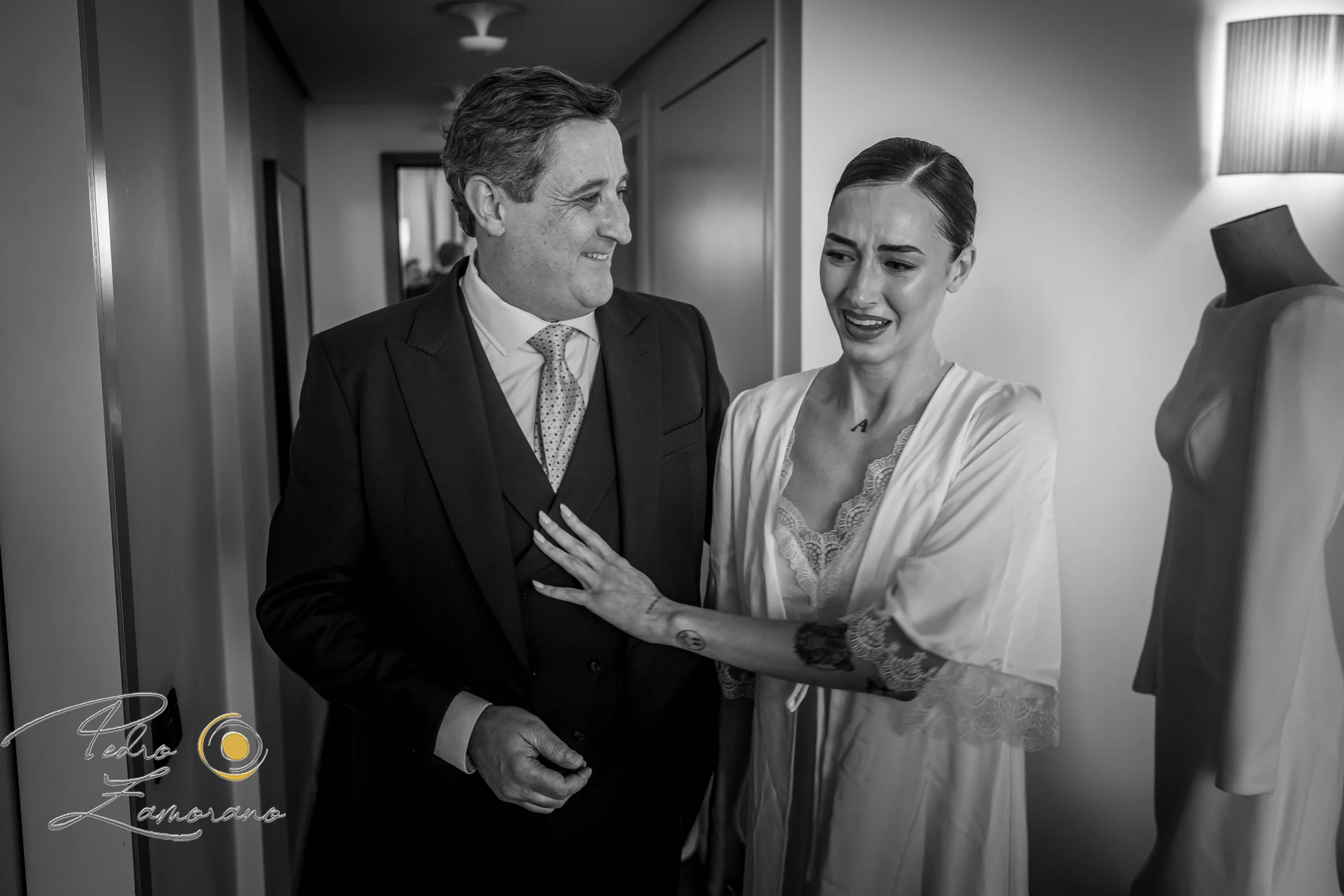 Novio con familiares durante los preparativos en una fotografía en blanco y negro.