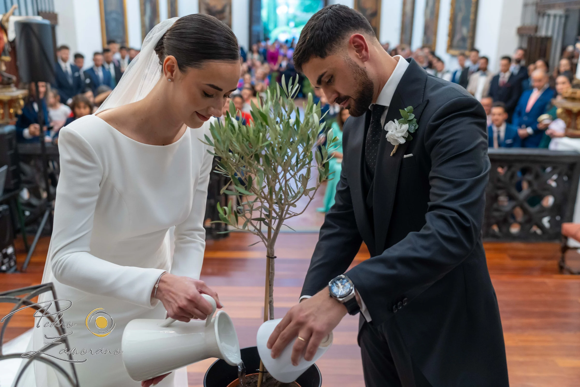 Novios participando en un ritual simbólico durante la ceremonia de boda.