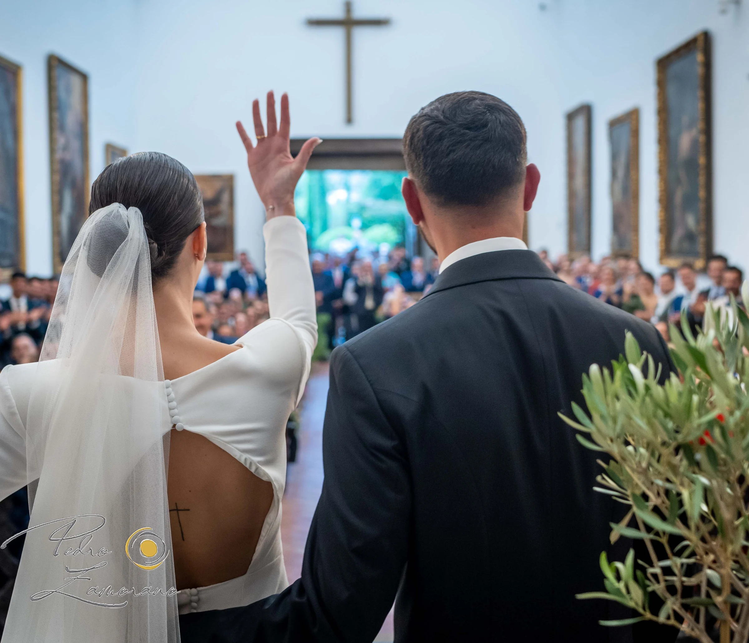 Novia durante la entrada a la ceremonia acompañada por invitados.