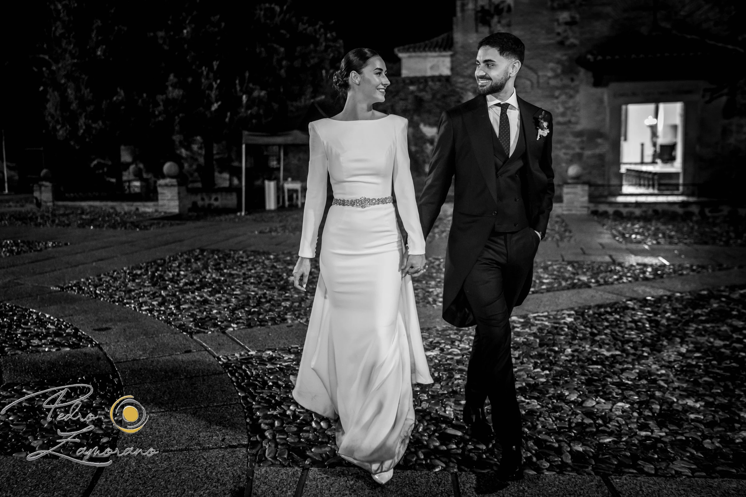 Novios caminando por los jardines del cigarral en una fotografía en blanco y negro.