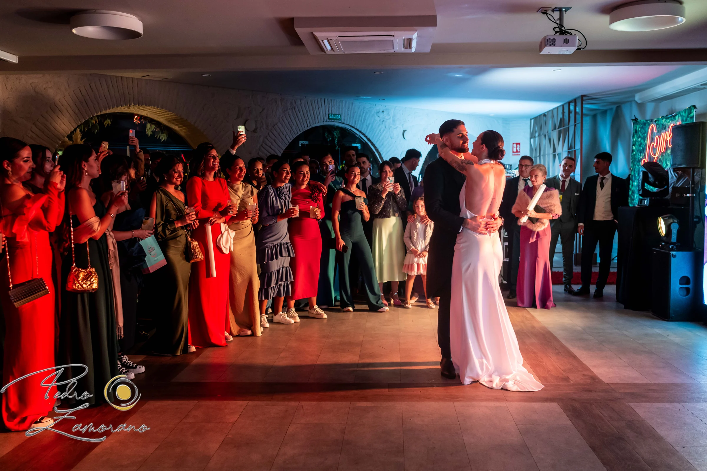 Novios durante el primer baile rodeados por familiares e invitados.
