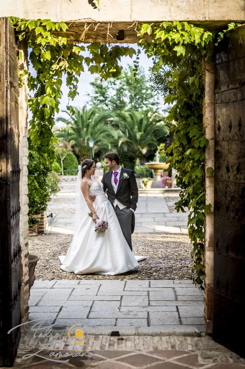 Novia caminando por un pasillo ajardinado del Cigarral del Ángel Custodio.