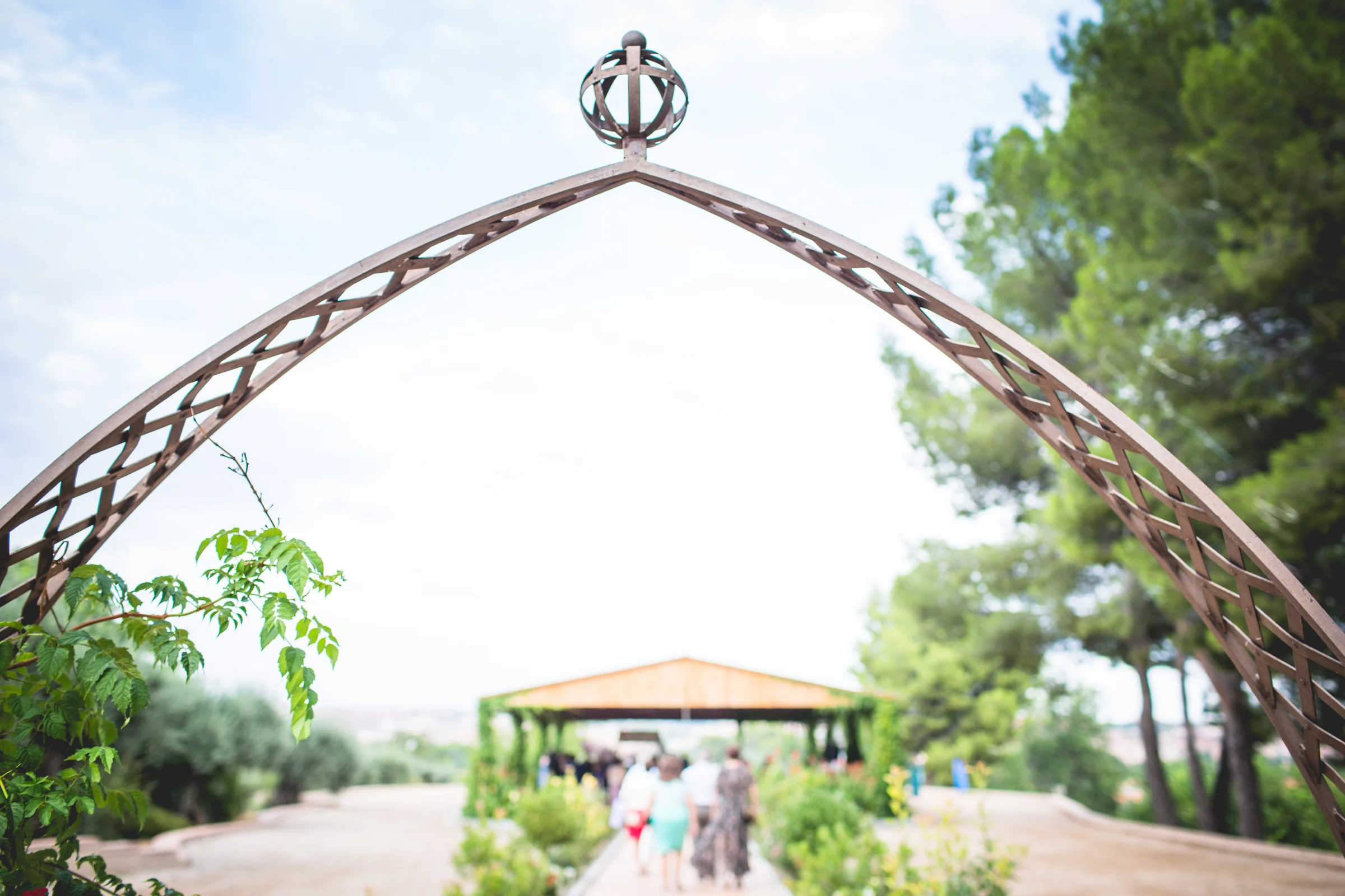 Arco decorativo en los jardines del Cigarral del Ángel Custodio con la ceremonia al fondo.