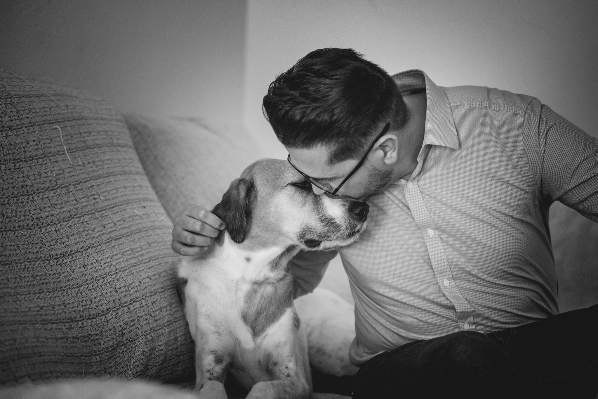 Novio acariciando y besando a su perro durante los preparativos de boda.