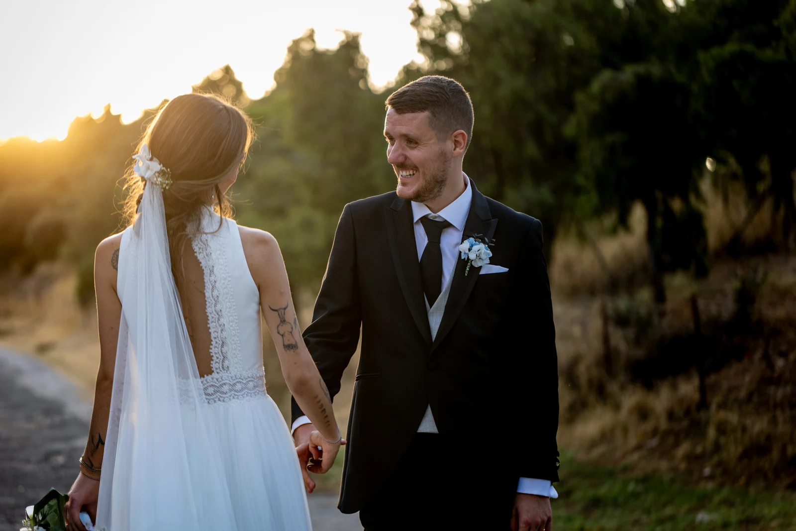 Novios se besan inclinados mientras los invitados lanzan confeti blanco y dorado.