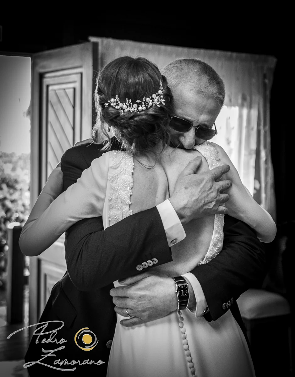 Abrazo emotivo de la novia con un familiar en una boda en Complejo La Cigüeña