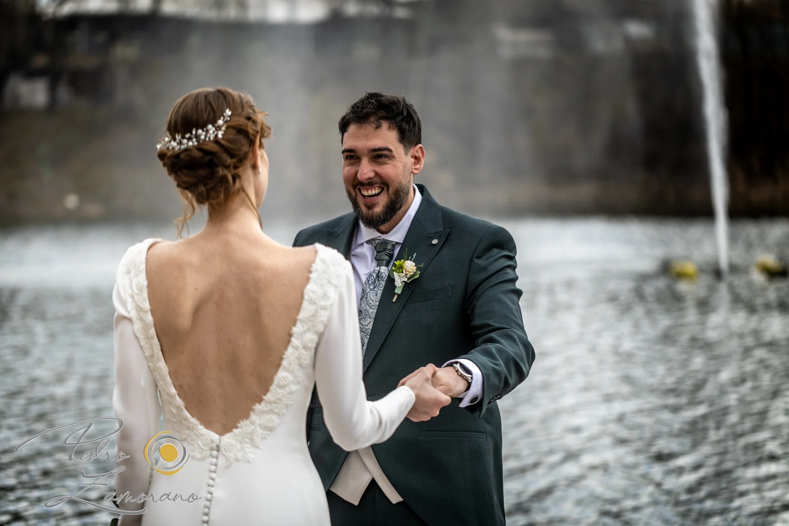 Novios riendo junto al lago en una boda en Complejo La Cigüeña