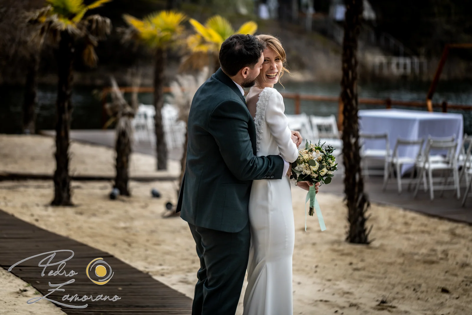 Novios abrazados junto al lago en una boda en Complejo La Cigüeña