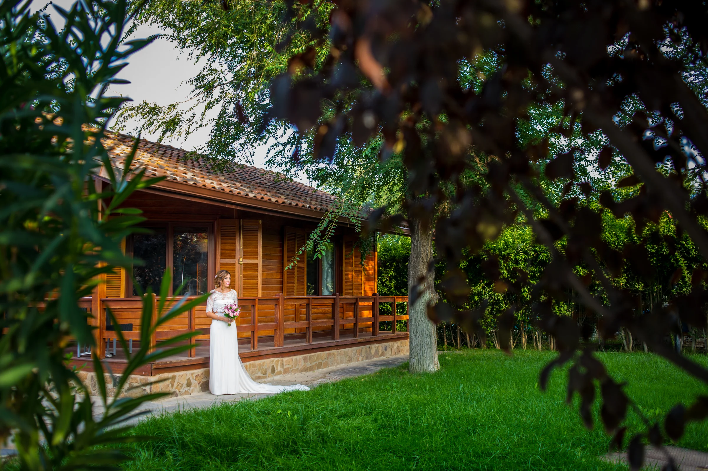 Novia caminando junto a una cabaña de madera en una boda en Complejo La Cigüeña