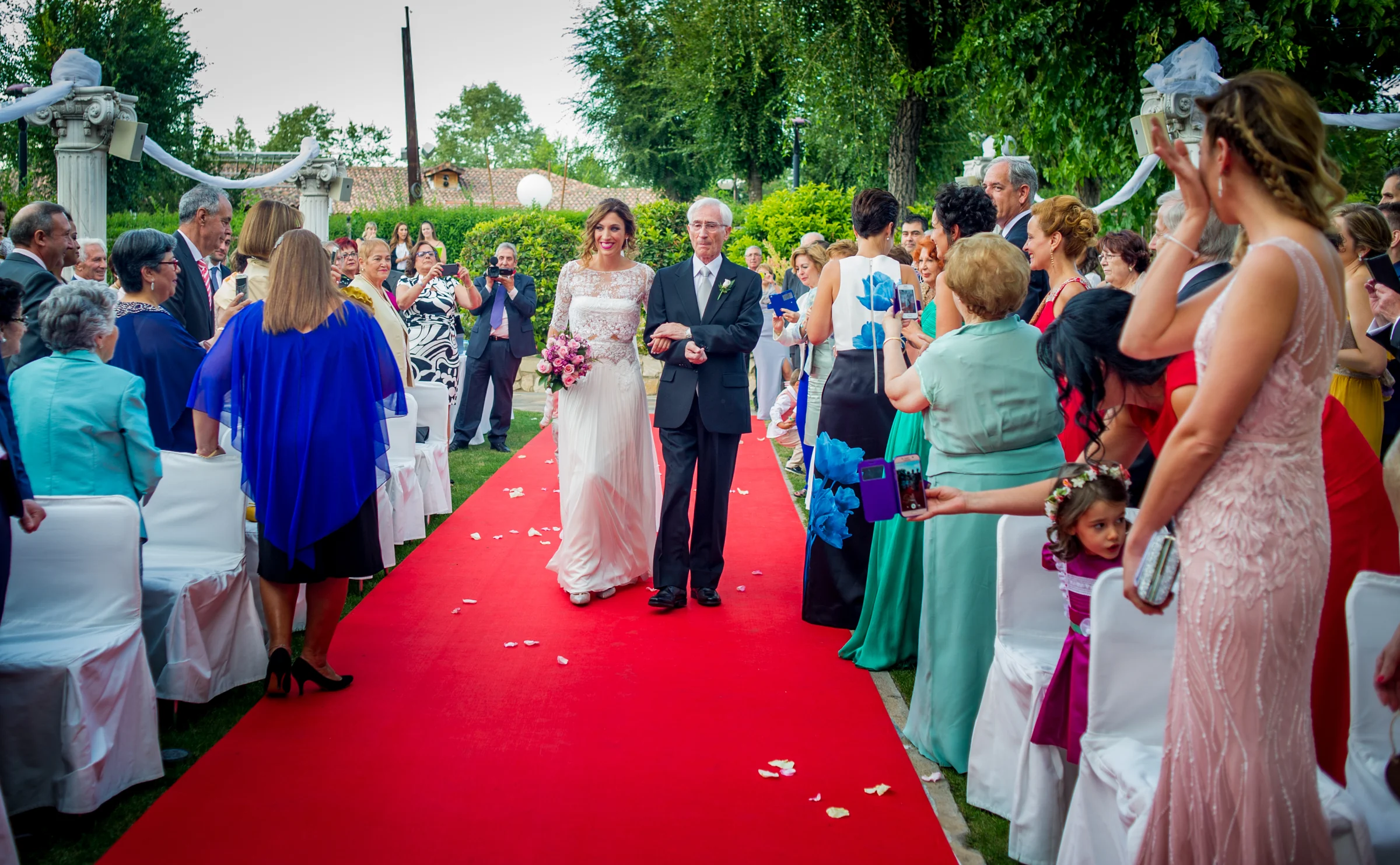 Entrada de la novia por la alfombra roja en una boda en Complejo La Cigüeña