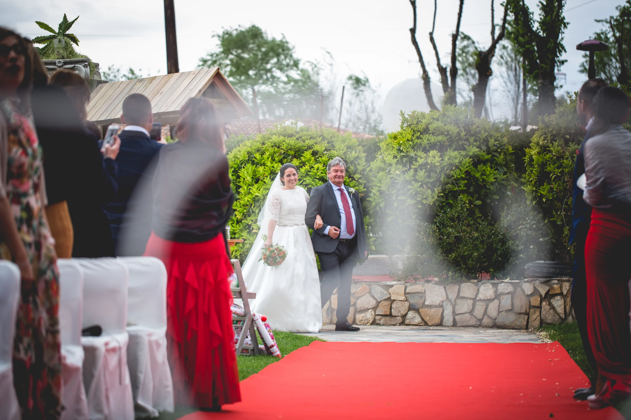 Novia llegando a la ceremonia exterior en una boda en Complejo La Cigüeña